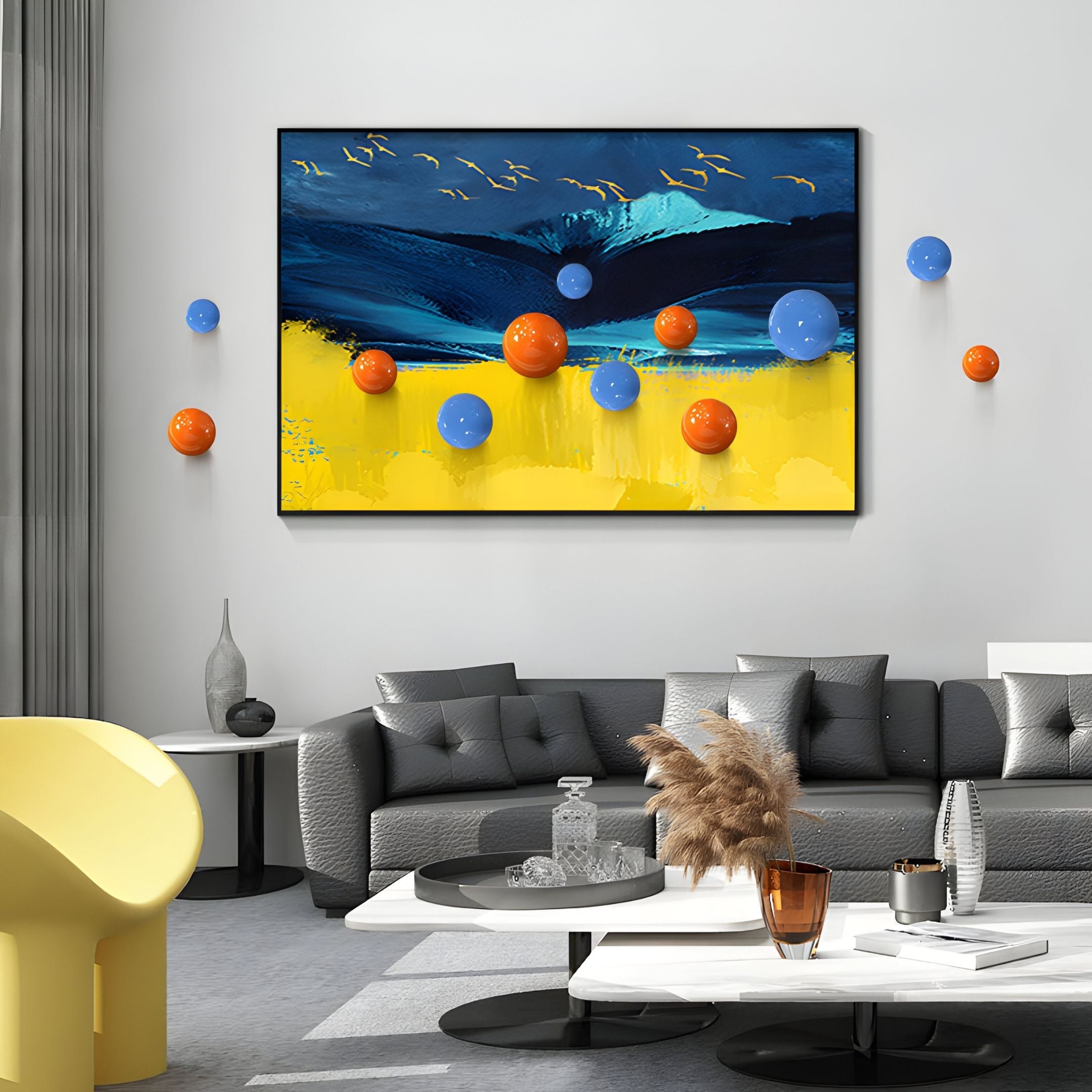 A modern living room features gray sofas, a white coffee table, and the Aerisphere Mountain Glow 3D Wall Art With Metal Balls by Giant Sculptures—an abstract artwork with blue, yellow, orange, and blue spheres—adding striking contemporary flair.
