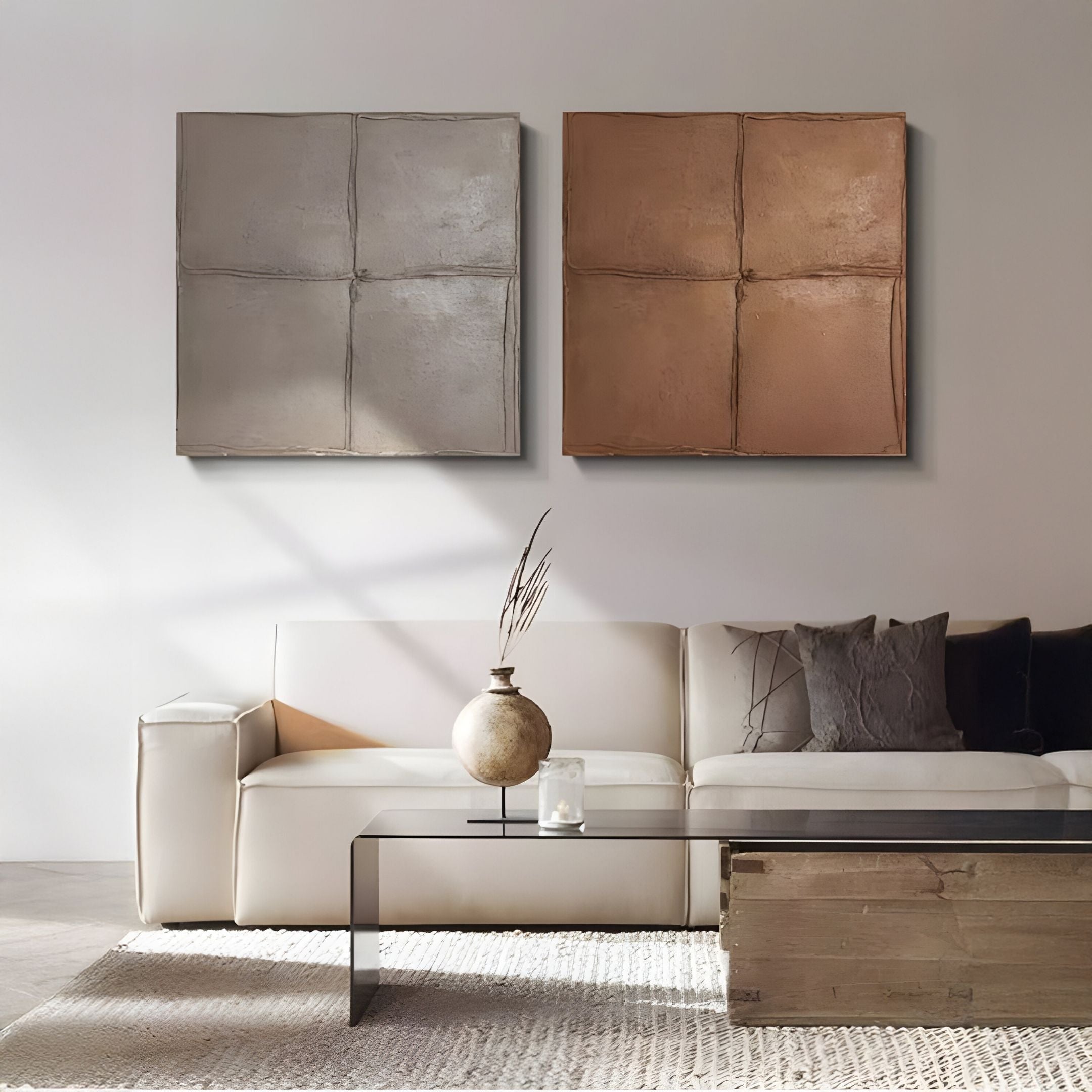 A modern living room with a white sofa, neutral cushions, glass coffee table, and textured vase is accented by Giant Sculptures' Terracrecta Taupe Painted Textured Square 3D Wall Art above the sofa for a chic touch.
