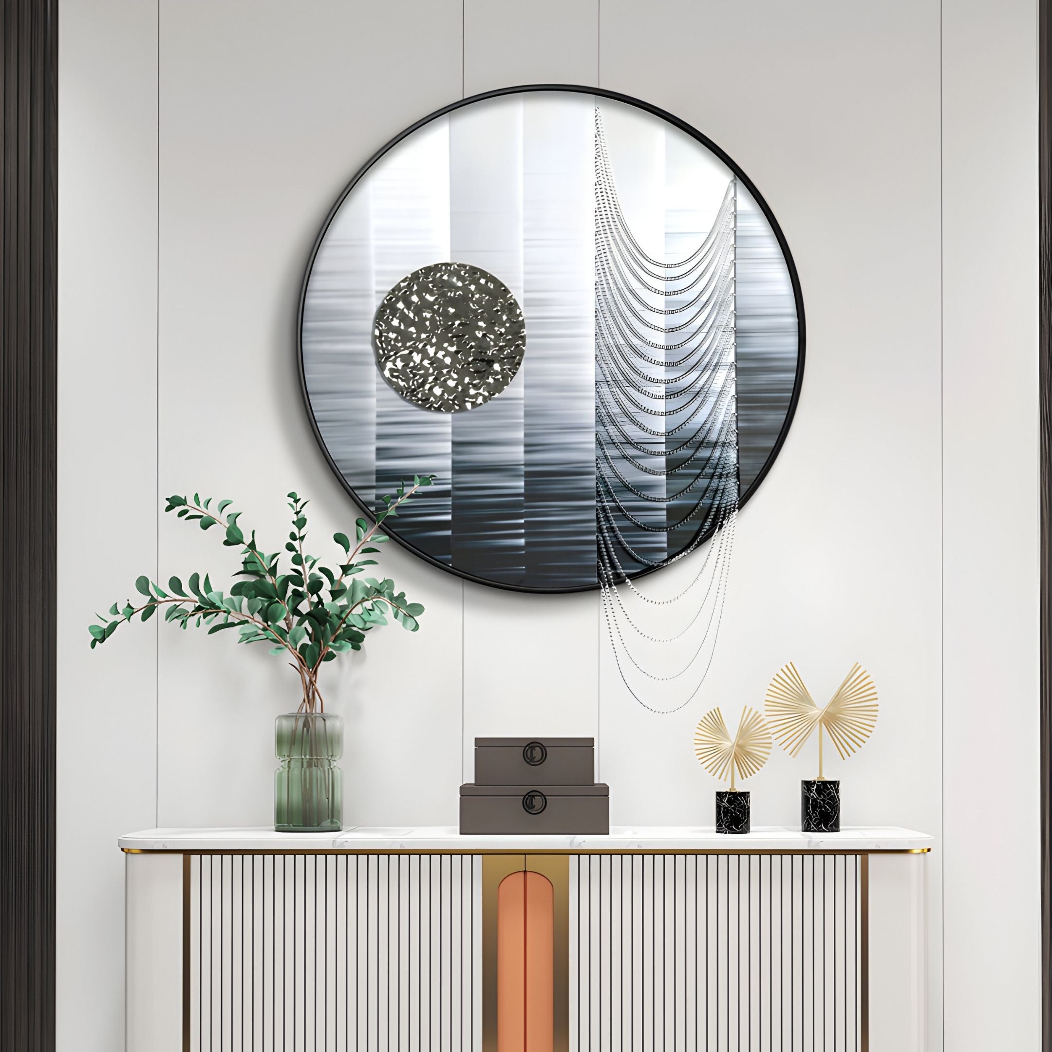 A modern entryway showcases the Lunastria Silver Disc & Chain Crystal Beads Round 3D Wall Art by Giant Sculptures, paired with a green plant in a glass vase, two stacked gray boxes, and gold decorative leaves on a white console table.