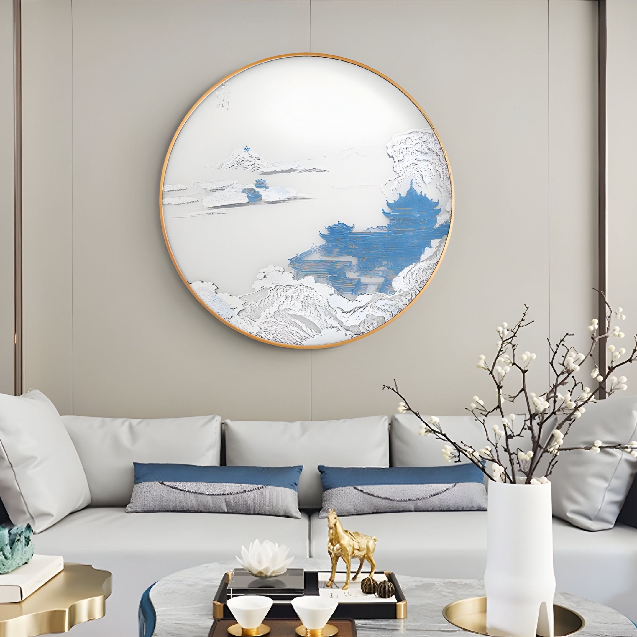 A modern living room featuring Giant Sculptures' Yunsei Misty Pavilion Vista Round Silk Relief 3D Wall Art, a white sofa with blue accent pillows, a gold horse figurine, and a white vase with blooming branches on a round coffee table.