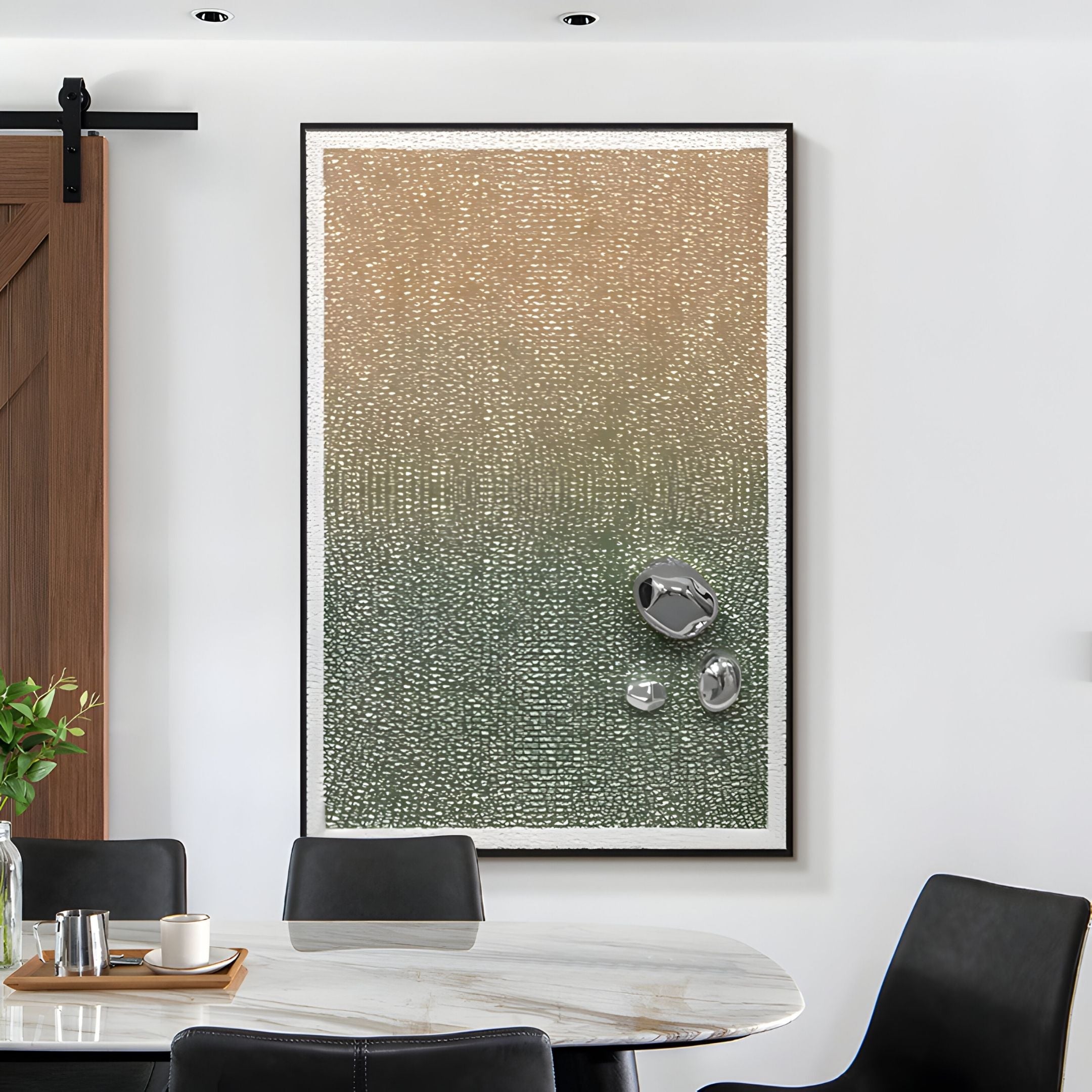 The Lumevara Sandstone Gradient & Chrome Droplet 3D Wall Art by Giant Sculptures features a beige-to-green gradient with three chrome droplets, displayed in a dining room with a round marble table and black chairs.