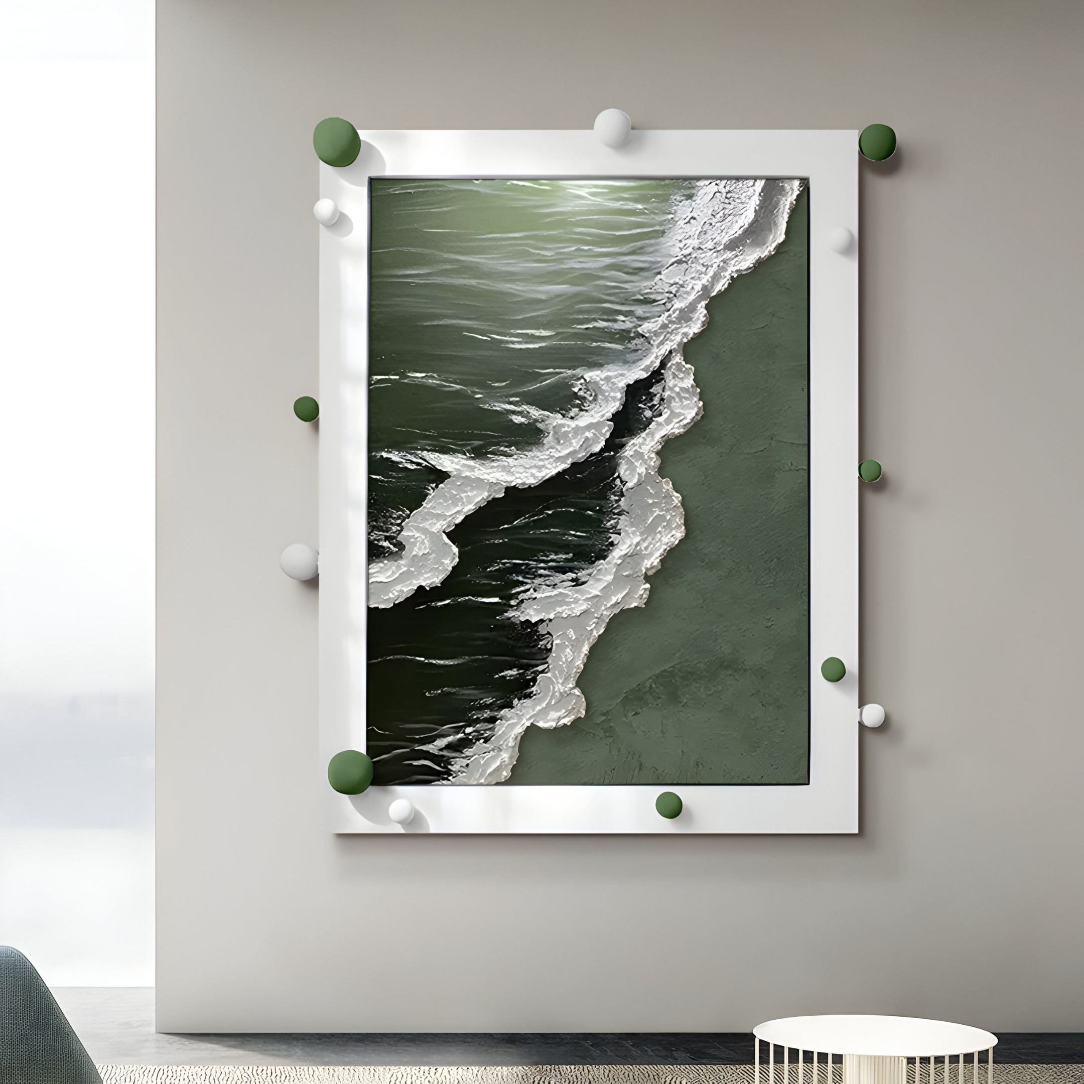 The Vivexa Green Shoreline Textured Ocean Abstract 3D Wall Art by Giant Sculptures, featuring green and white hues with a textured frame, hangs on a gray wall above a small white table and part of a green chair.