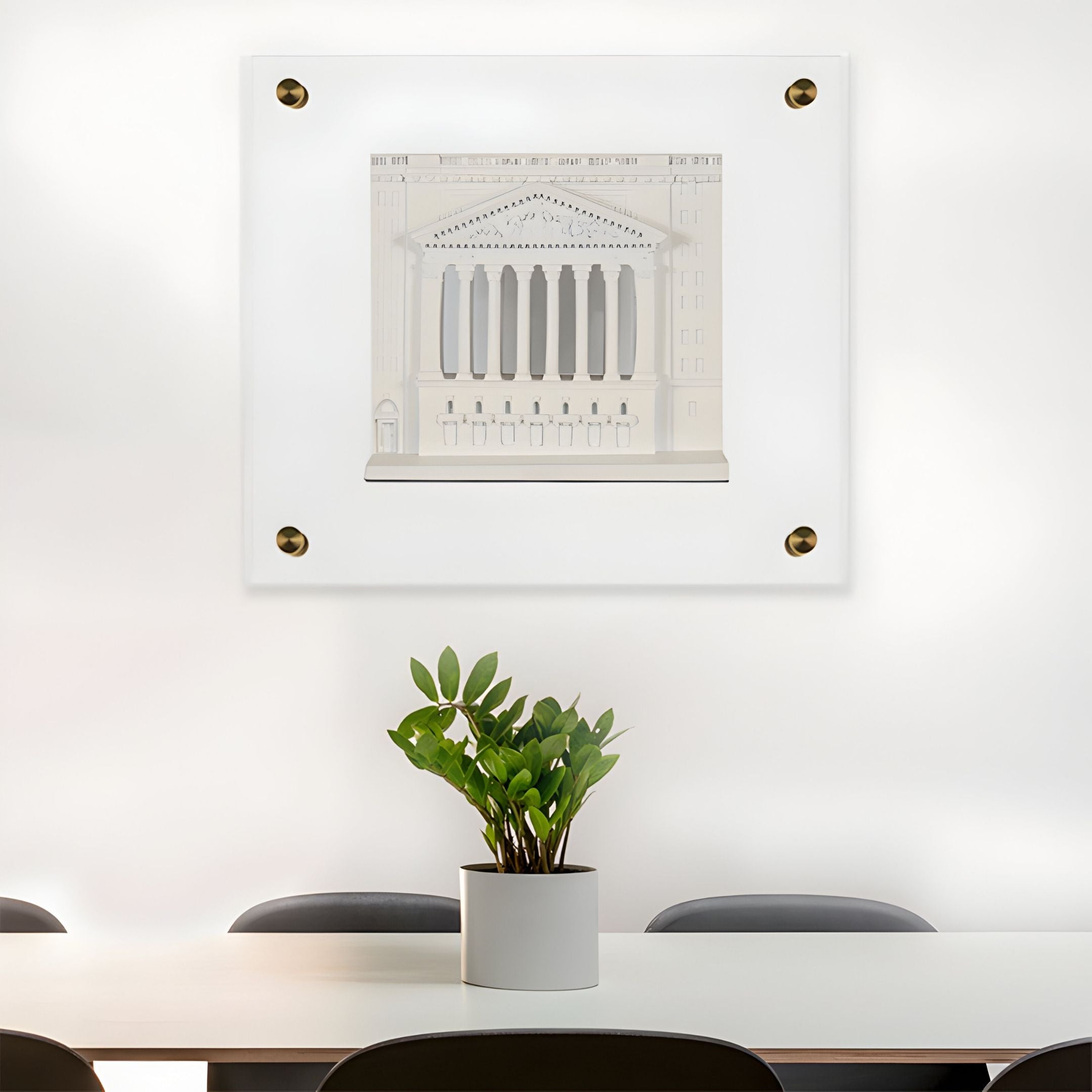 A potted plant rests on a white table with black chairs. Behind it, the Capitolique White Classical Facade 3D Wall Art by Giant Sculptures adds a neoclassical touch to the modern, minimalistic setting.