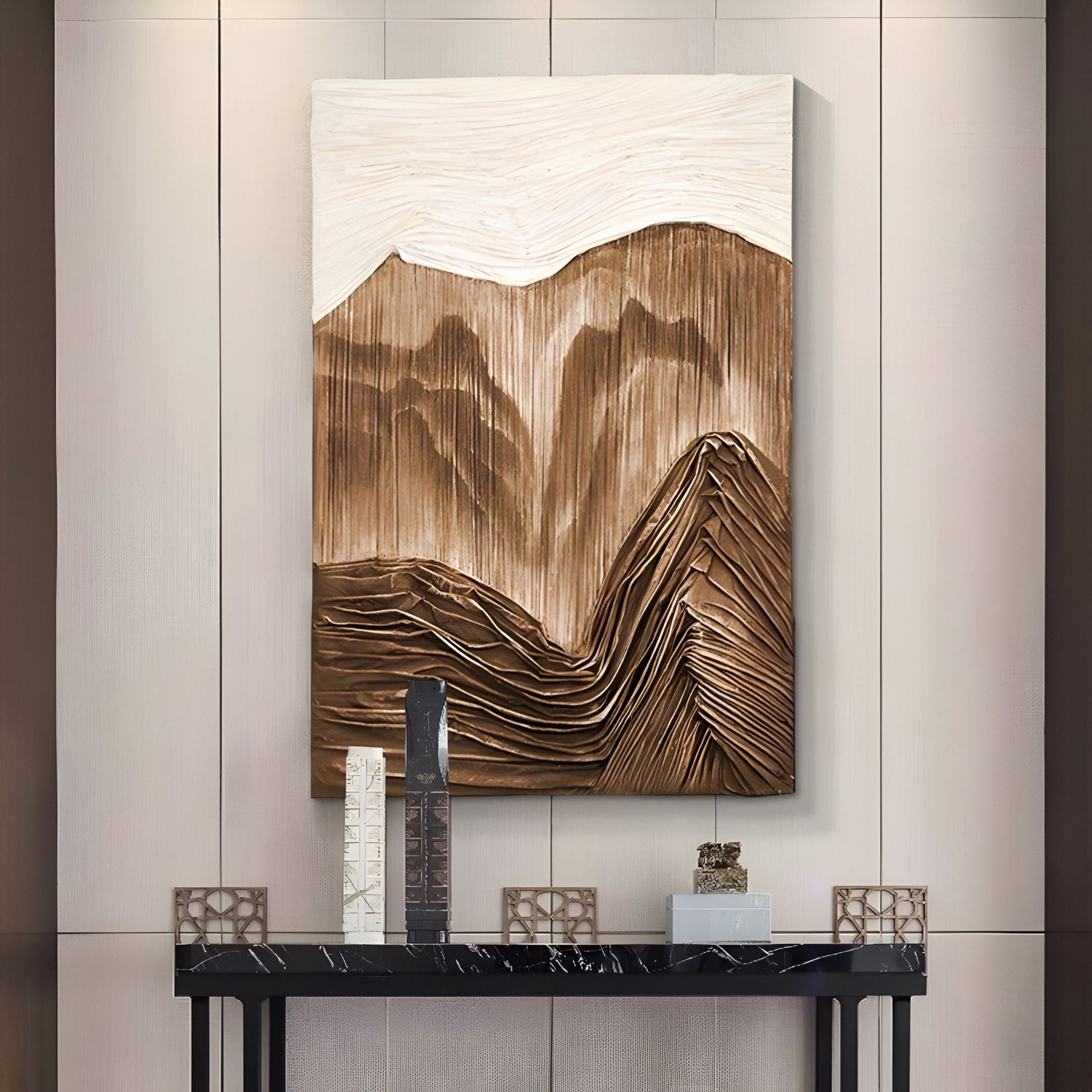 The Terralune Bronze Layered Ridge 3D Wall Art by Giant Sculptures features abstract brown and beige mountain shapes, creating a textured focal point above a black console with decorative objects in a modern interior.