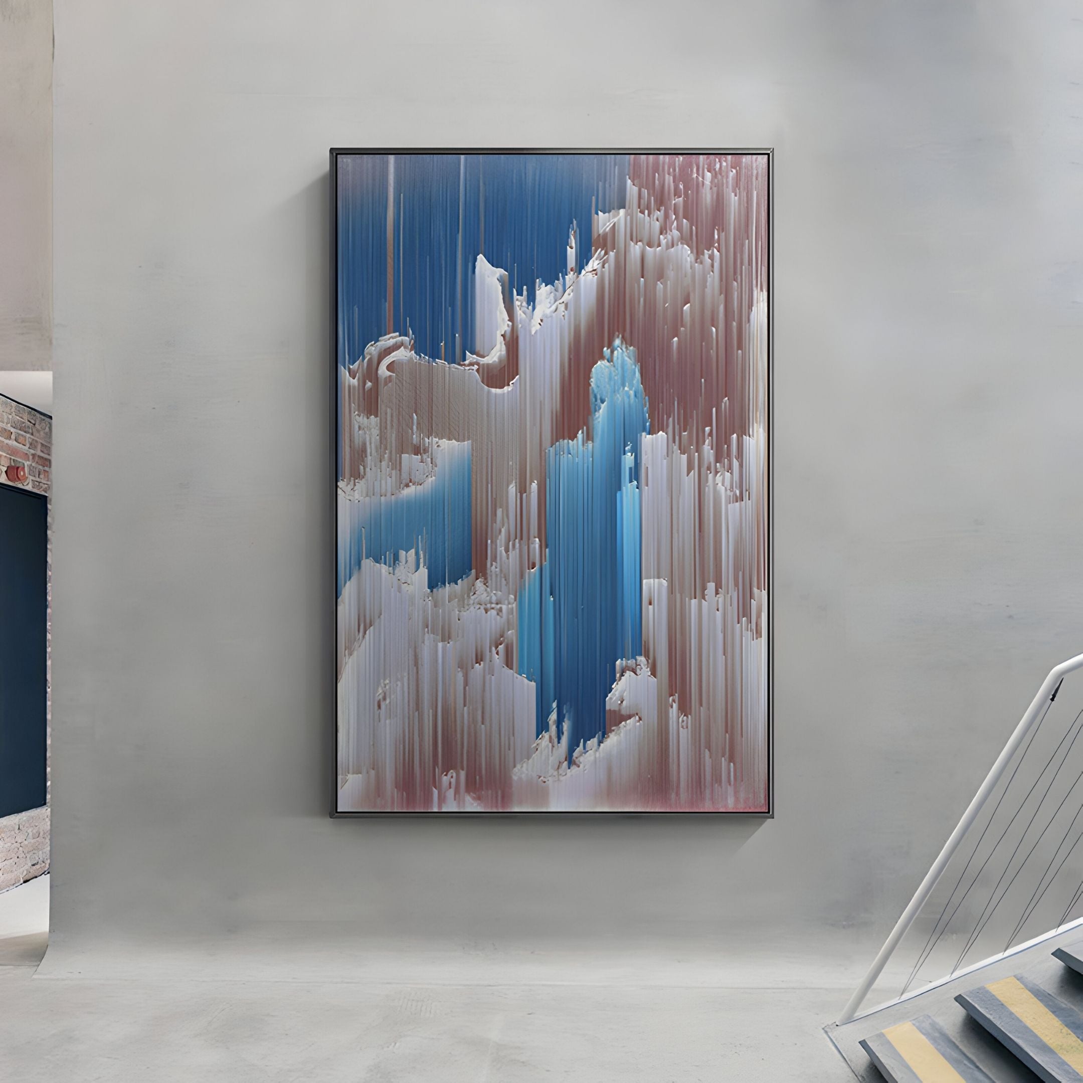 The Aerolune Rose & Blue Vertical Drift Rope 3D Wall Art by Giant Sculptures hangs on a light gray wall beside a staircase with metal rails, featuring vertical blue, pink, and white streaks in a digital glitch-inspired pattern.