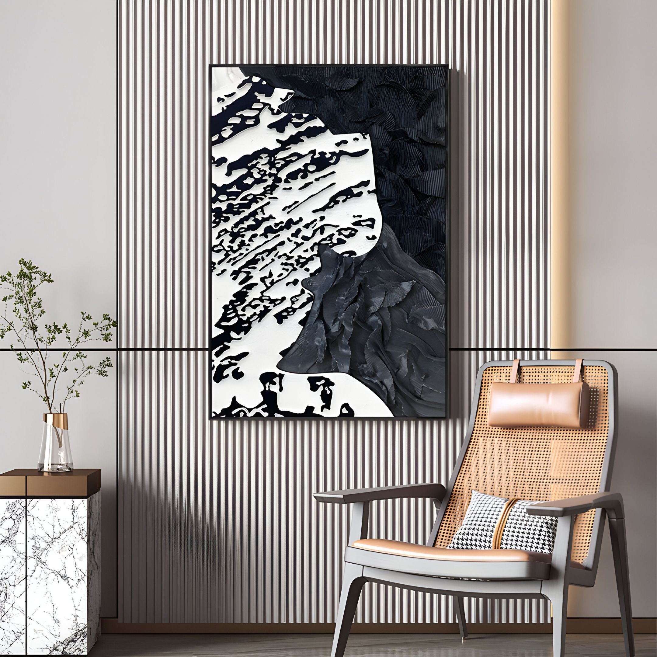 A modern living space featuring a rattan chair, a small marble-top table with a vase, and Giant Sculptures’ Nivoria III Black & White Textured Abstract 3D Wall Art on a vertically striped wall.