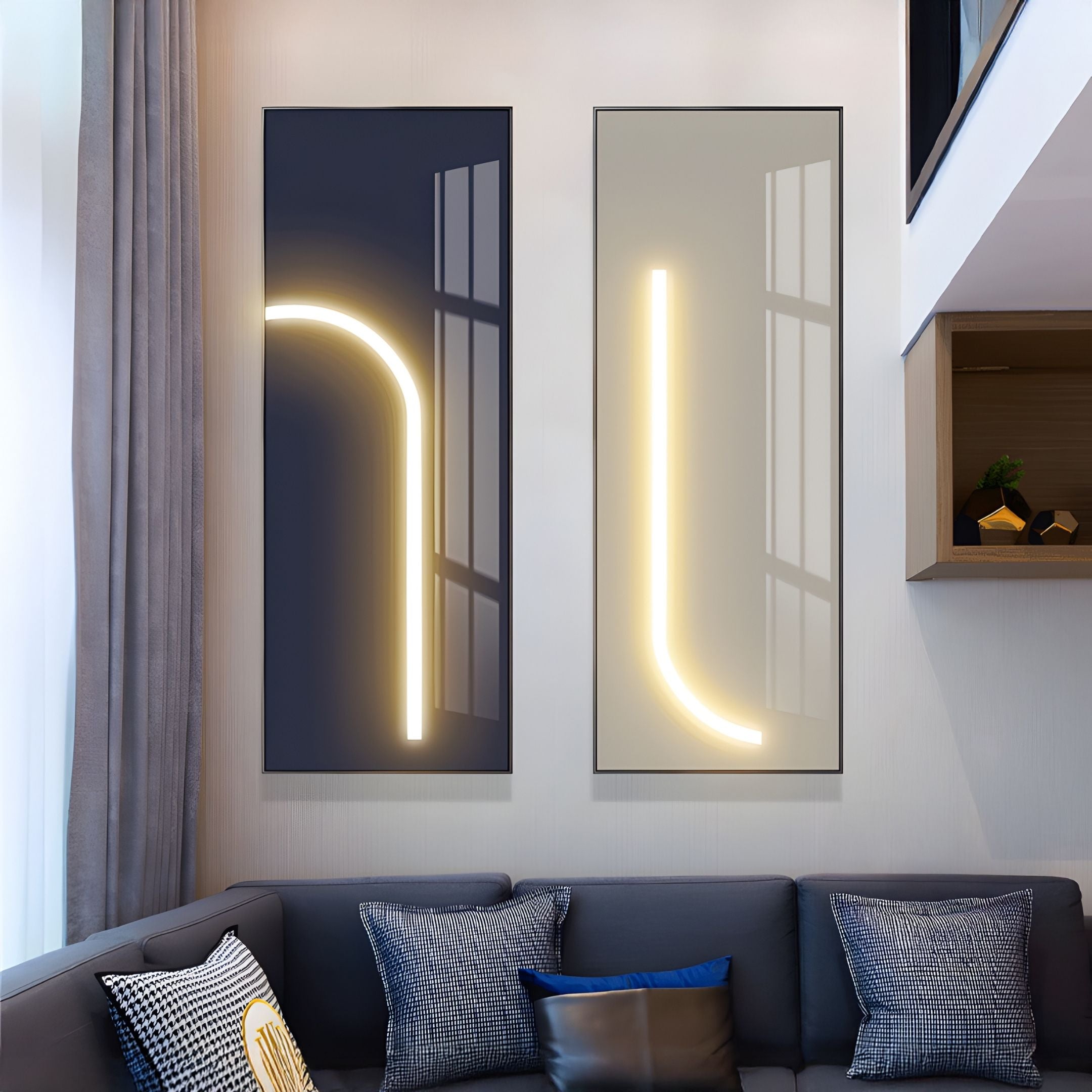 Two Luminarch Navy Curve LED Minimalist Wall Art panels by Giant Sculptures hang above a gray sectional with patterned cushions, adding a modern touch to a living room with tall windows and neutral-colored walls.