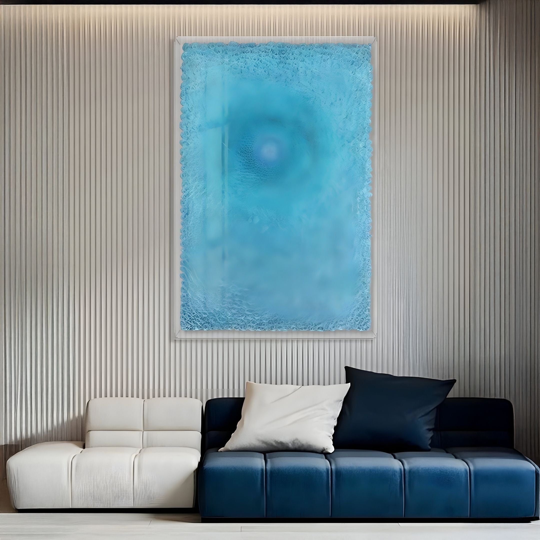 A modern living room features a white and dark blue sofa, two pillows, and the Lumora Aqua Blue Acrylic Framed 3D Paper Wall Art by Giant Sculptures on a textured gray wall, with soft lighting highlighting the clean, minimalist décor.