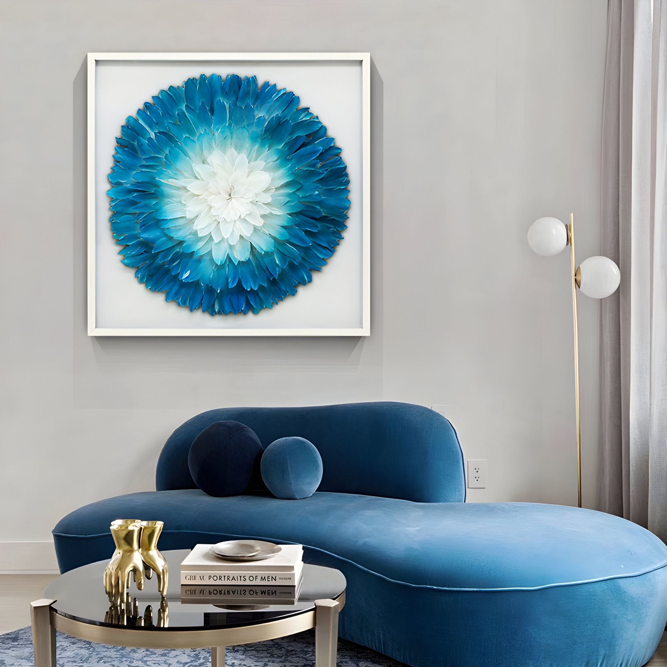 A modern living room with a blue chaise lounge, a round black coffee table with books and gold decor, and Giant Sculptures' Plumesse Aqua Bloom Layered Feather 3D Wall Art featuring blue and white petals above the couch.