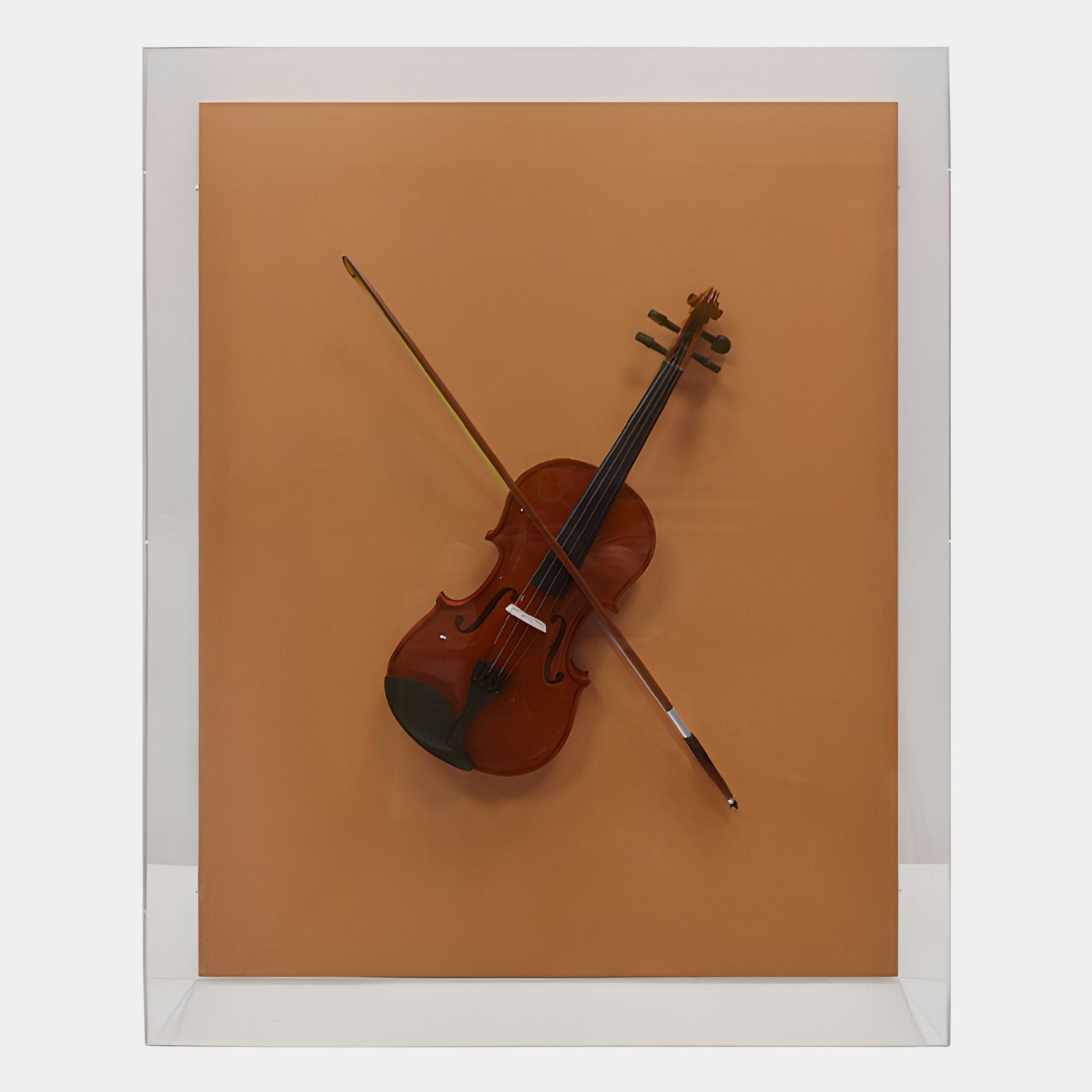 The Archetto Terra Violin Acrylic Framed 3D Wall Art by Giant Sculptures features a violin and bow mounted diagonally on an orange-brown backdrop in a transparent acrylic frame, creating striking and elegant wall art.