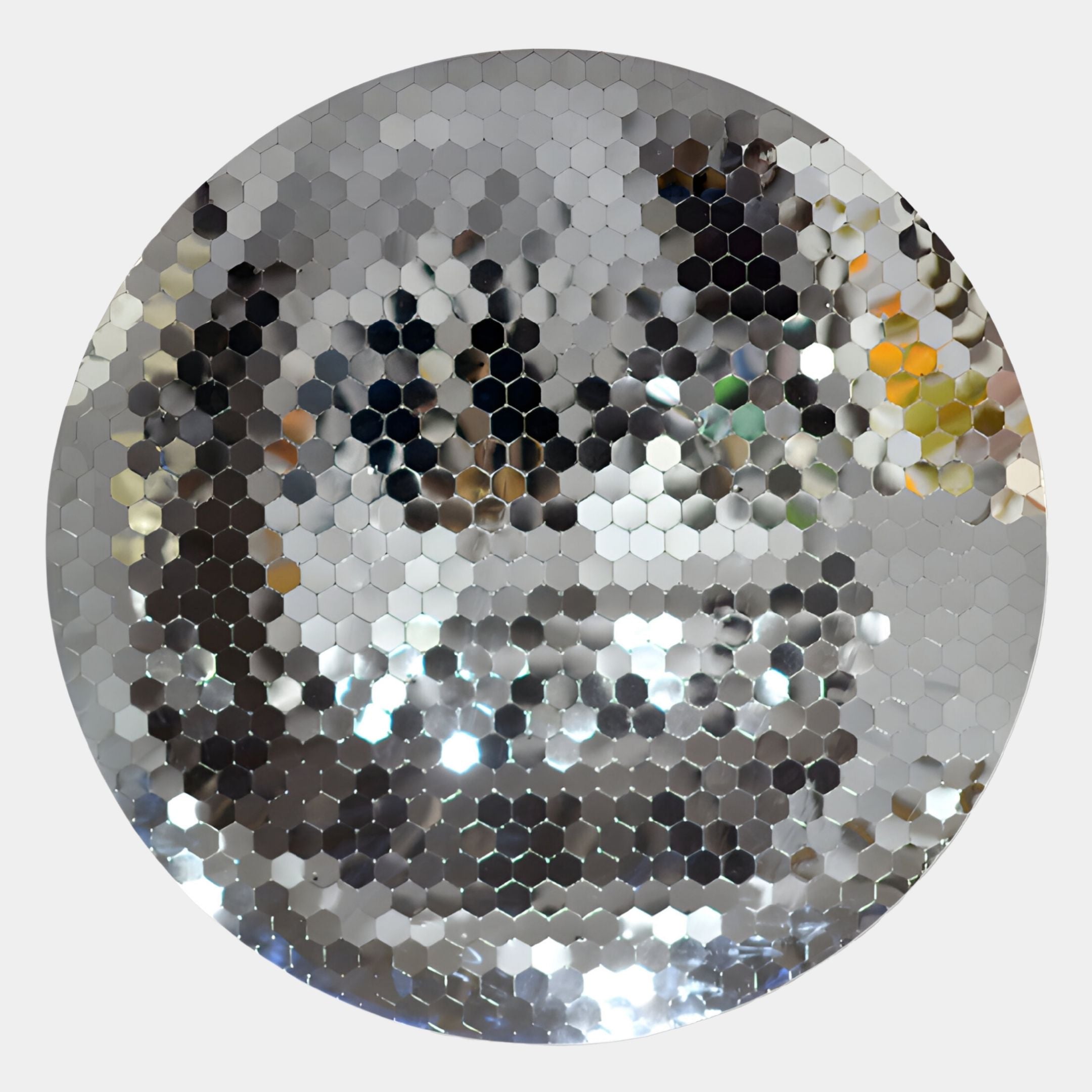 The Lumineris Silver Hexa-Mirror Circular Metal 3D Wall Art by Giant Sculptures features small hexagonal mirrors that reflect colors and shapes, creating a stunning mosaic effect on any light background.