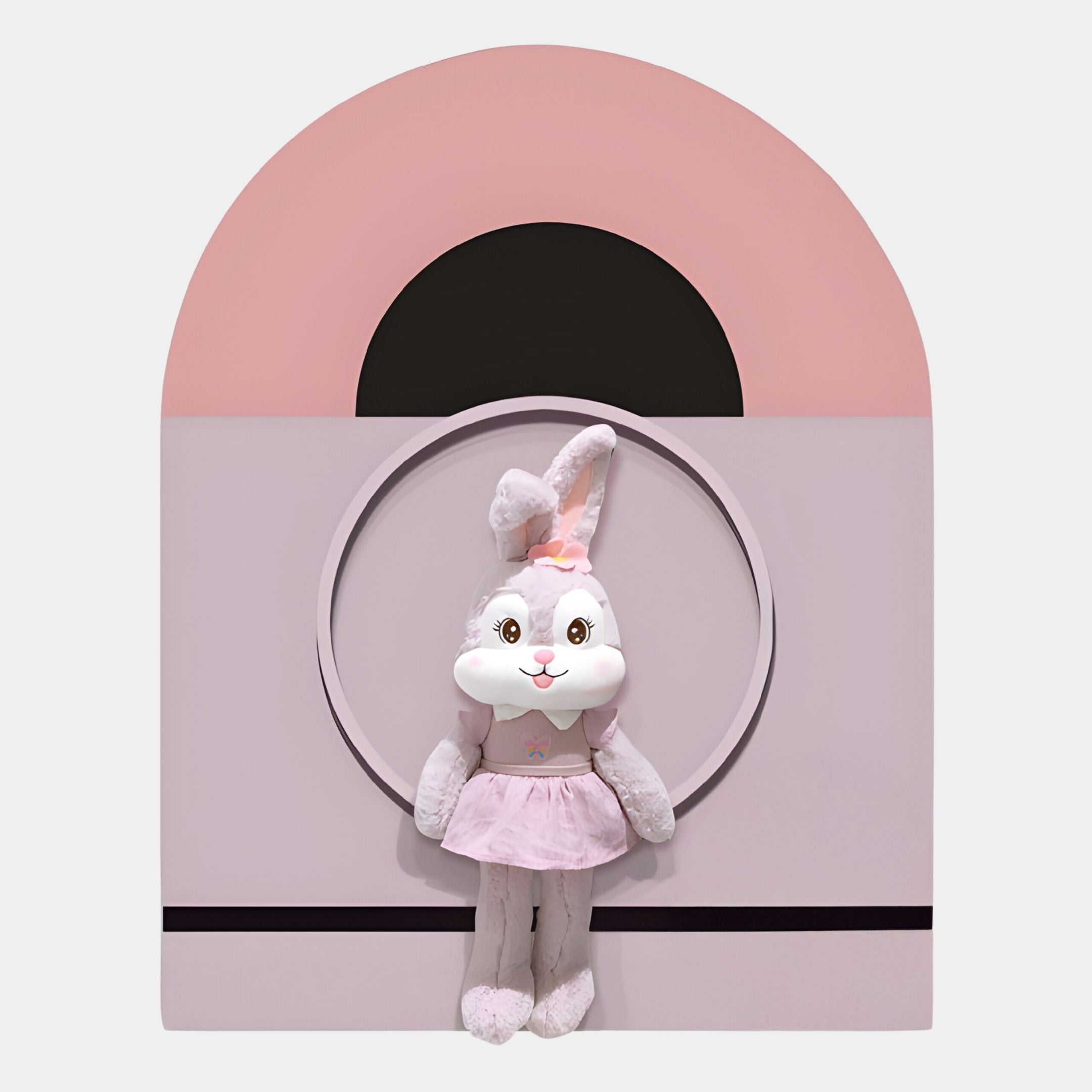 The Cuddiloft Pink Bunny Plush Display 3D Wall Art by Giant Sculptures features a plush bunny in a pink dress and bow, set before a pastel pink and black arch—ideal as pink bunny room decor or adorable nursery wall art.