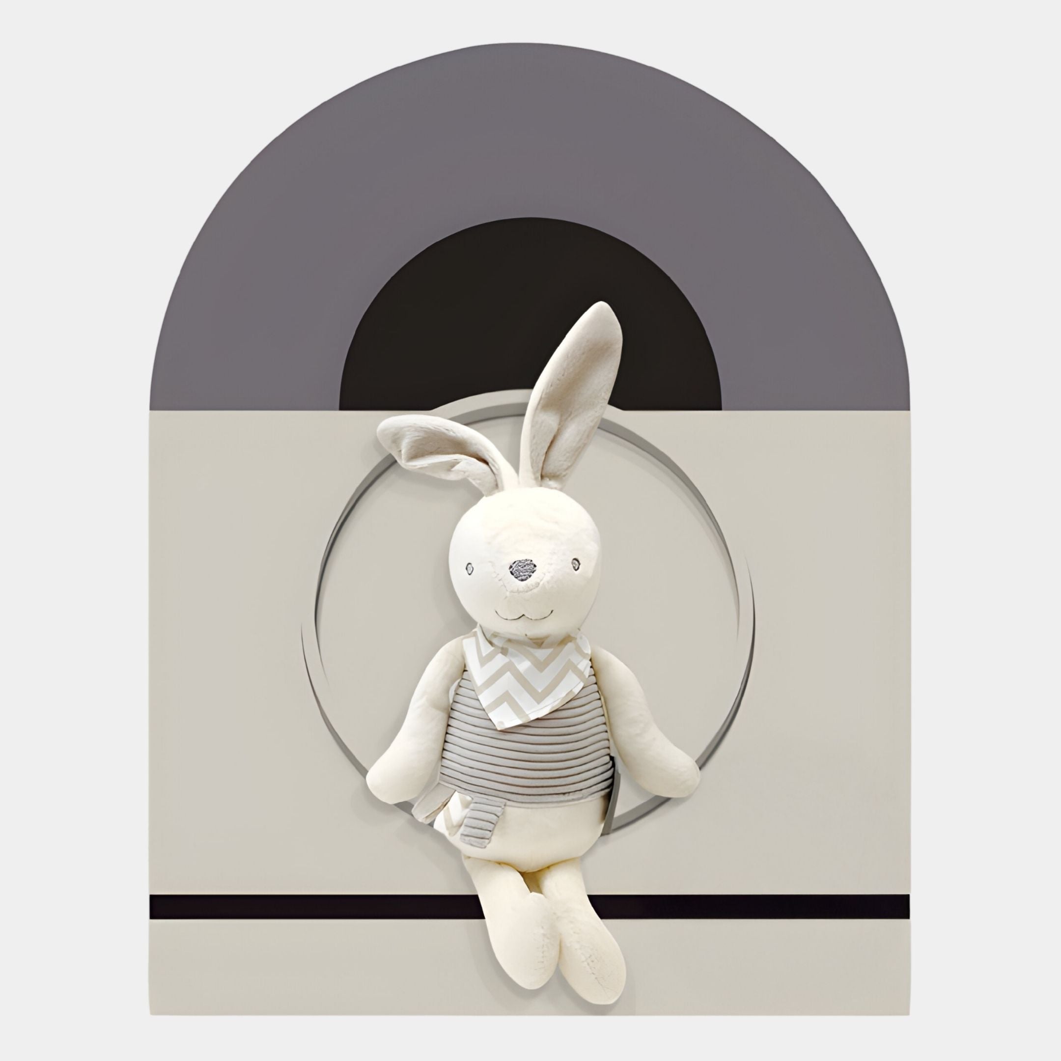 The Cuddiloft Cream Bunny Plush Display 3D Wall Art by Giant Sculptures features a plush bunny with long ears and a striped outfit against geometric arches, perfect for adding charming Nordic style to your child's room in soft gray tones.