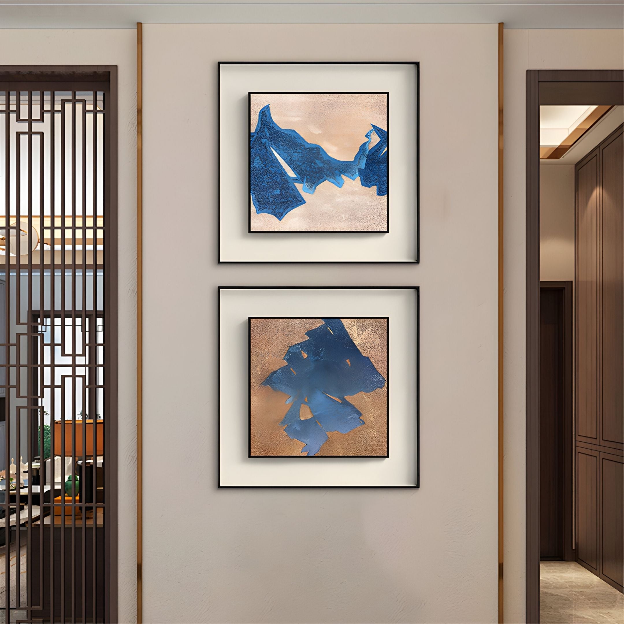 The Stratum Blue Crest Textured Abstract Framed Wall Art by Giant Sculptures, featuring bold blue shapes on beige, is displayed in black frames, one above the other, on a light wall in a modern hallway.