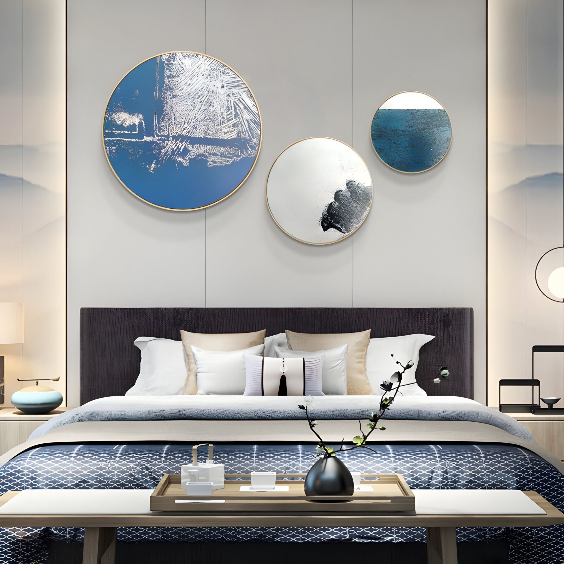 A modern bedroom with a neatly made bed showcases blue and white bedding, multiple pillows, and a dark headboard. Above the bed, four Auralune Frosted Trace Blue Abstract Round 3D Wall Art by Giant Sculptures provide striking contemporary decor.