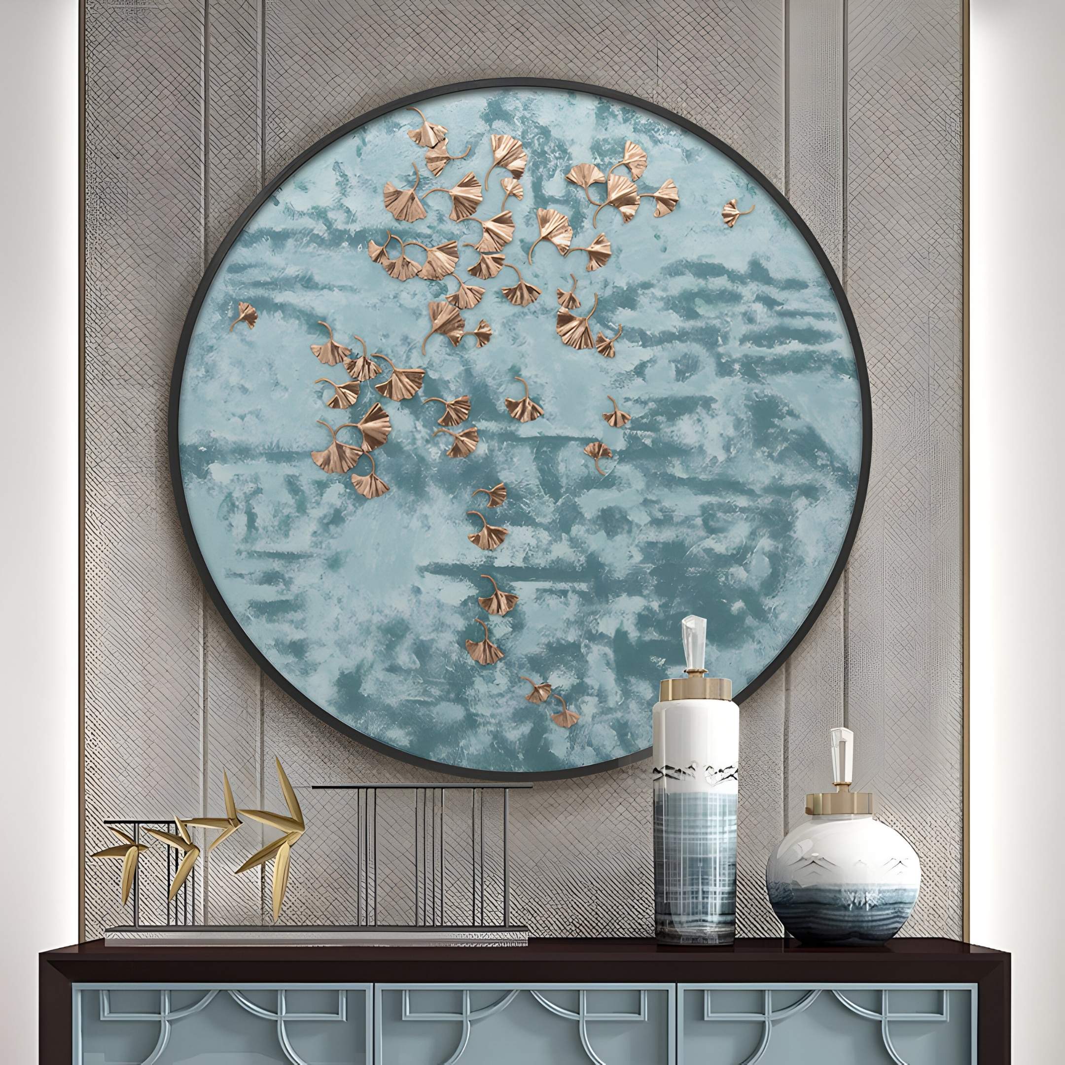 The Florivonne Gilded Metal Leaf Round 3D Wall Art by Giant Sculptures, featuring gold leaf accents on a blue abstract backdrop, hangs above a modern table with two blue and white gradient ceramic jars with gold lids and a gold abstract sculpture.