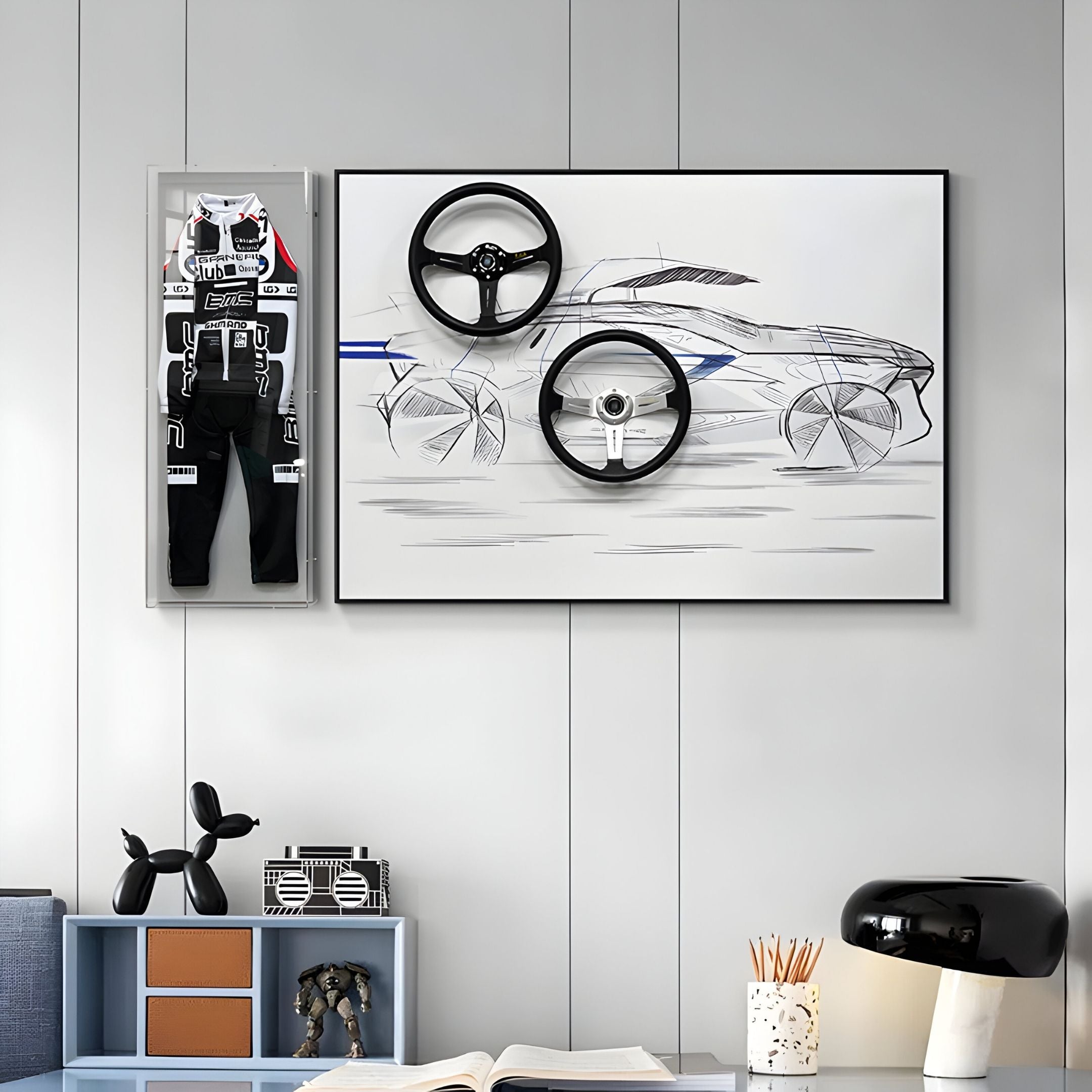 A modern room features Giant Sculptures' Apexline Steering Wheel Car Sketch 3D Wall Art—a framed car sketch with real wheels—paired with a mounted racing suit. Below, a desk displays books, a black lamp, and decor for bold racing-themed style.