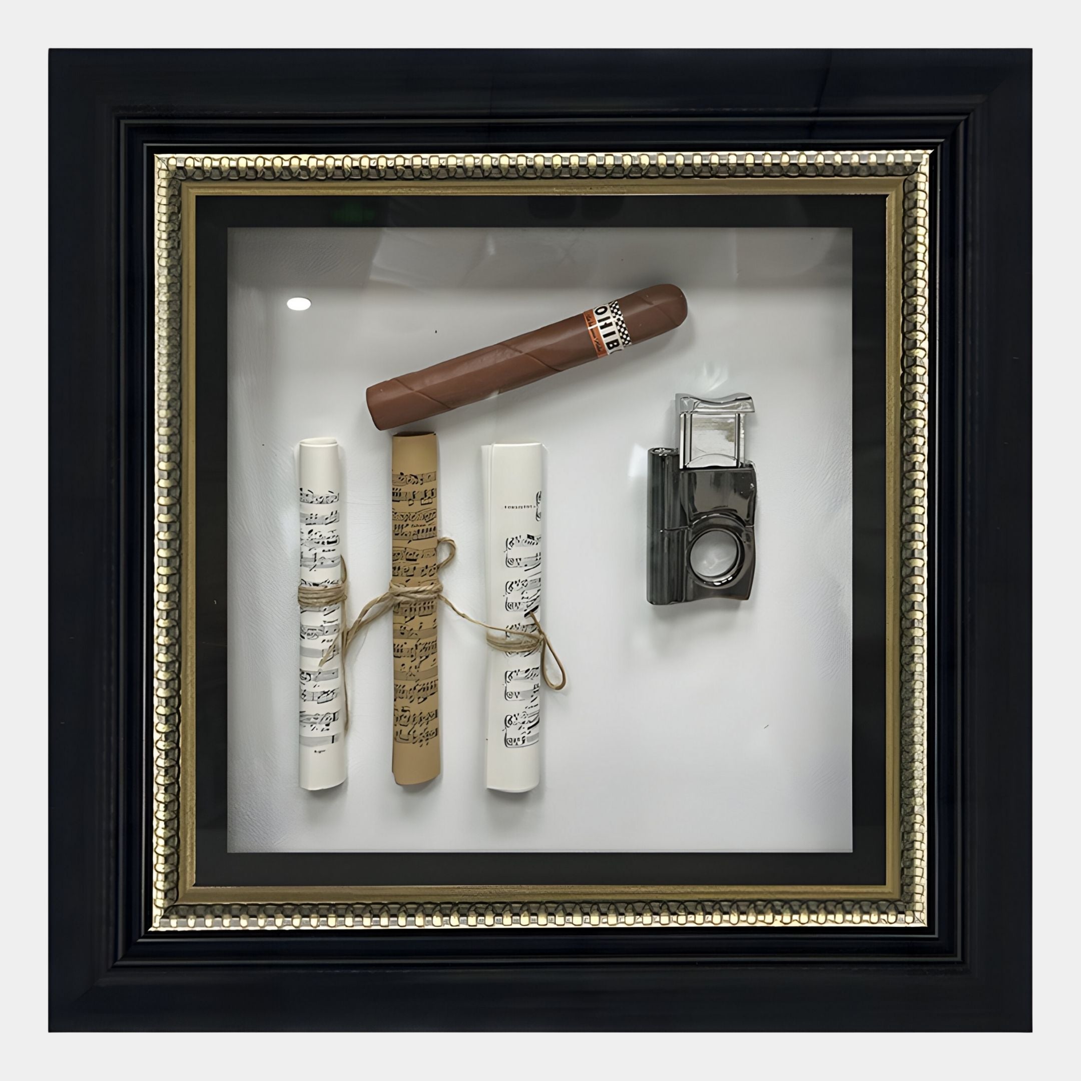 The CurioVault Cigar & Sheet Music Framed Wall Art by Giant Sculptures displays three rolled music sheets, a cigar, and a vintage camera arranged on white, housed in an ornate black and gold frame.