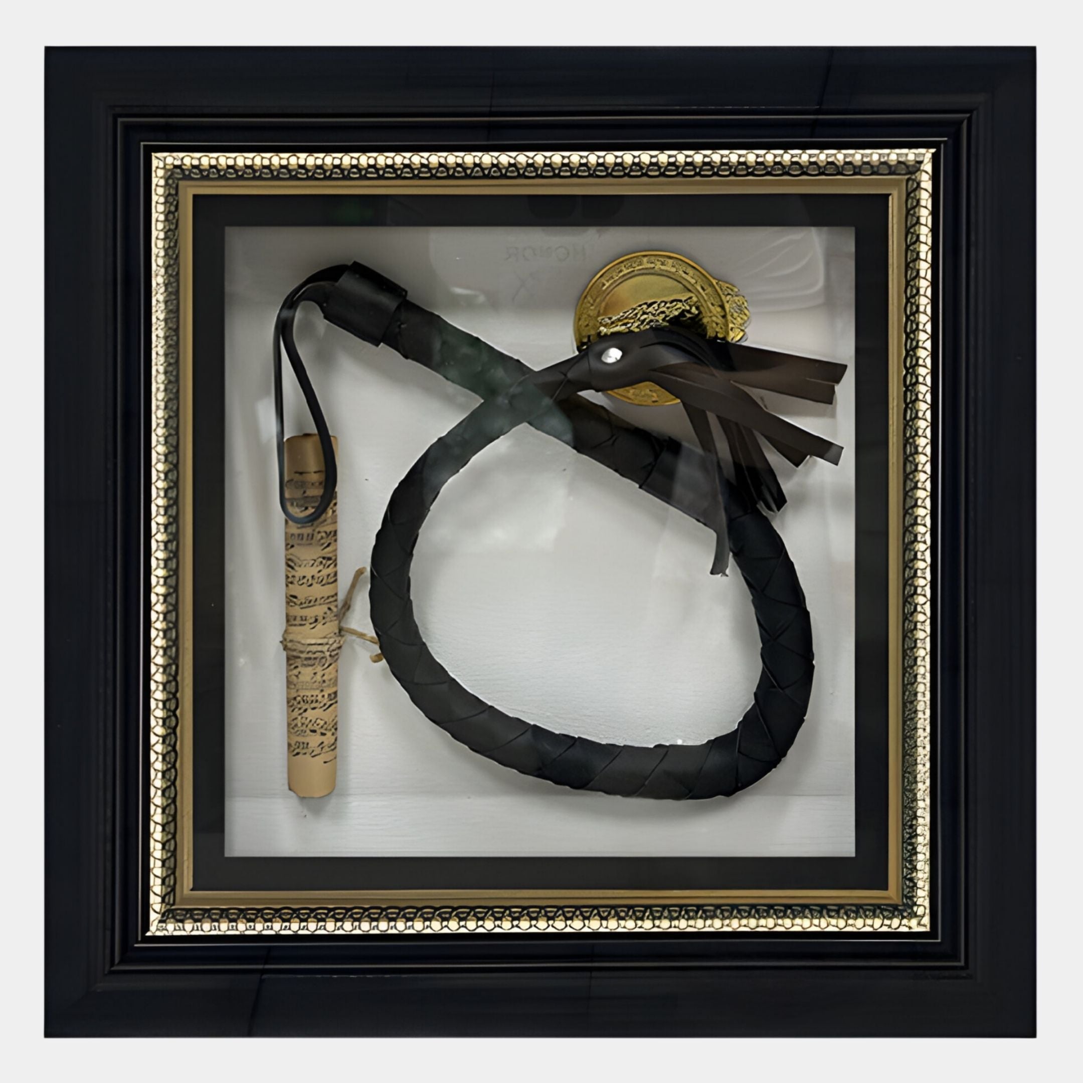 The CurioVault Braided Leather Loop & Medallion Framed Wall Art by Giant Sculptures showcases a black braided leather loop, rolled sheet music, and a gold medallion on white with a black and gold border.