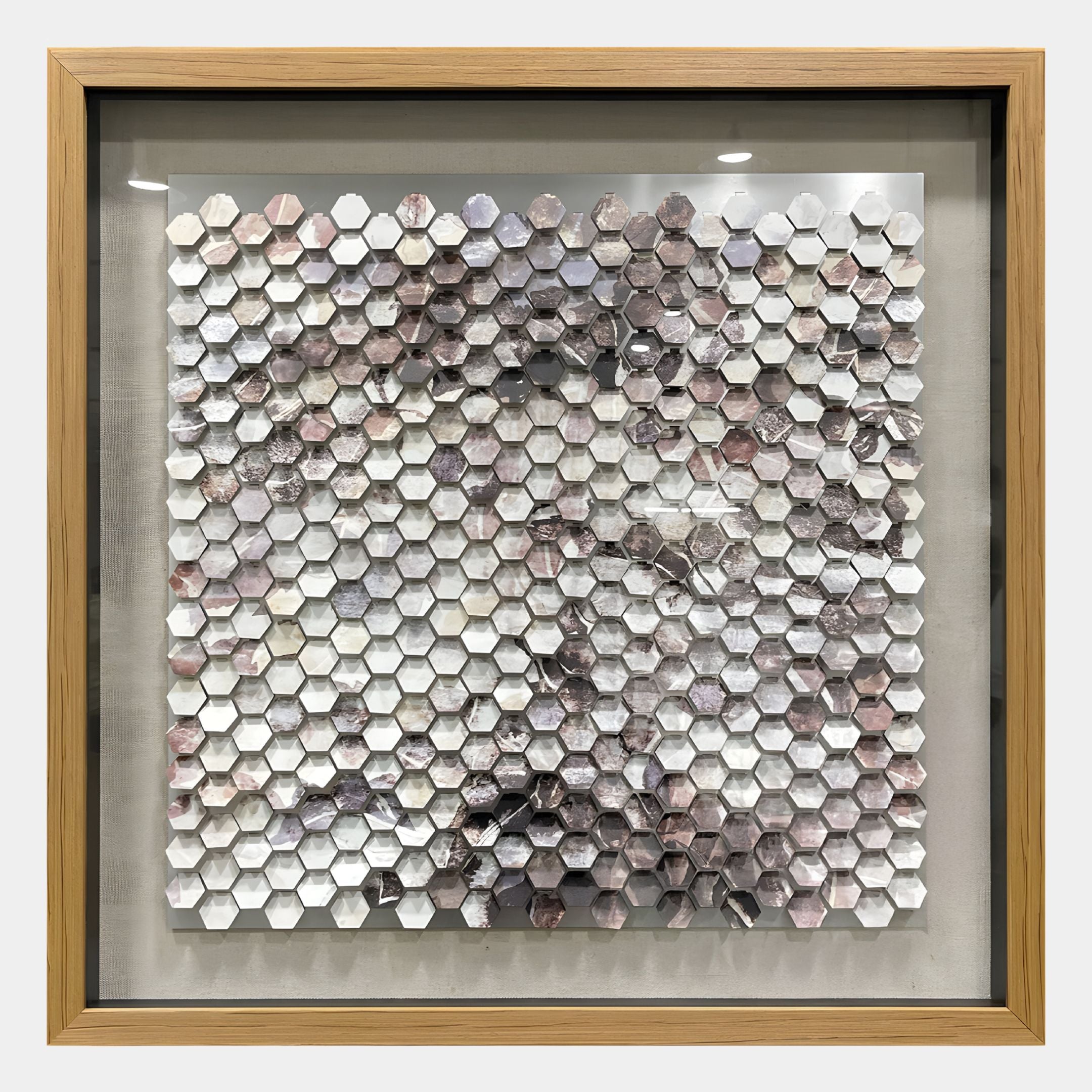 The Tessora White & Smoke Hex Mosaic Metal 3D Wall Art by Giant Sculptures features a grid of hexagonal tiles in soft white, gray, and pink shades—adding subtle elegance and modern style to any interior.