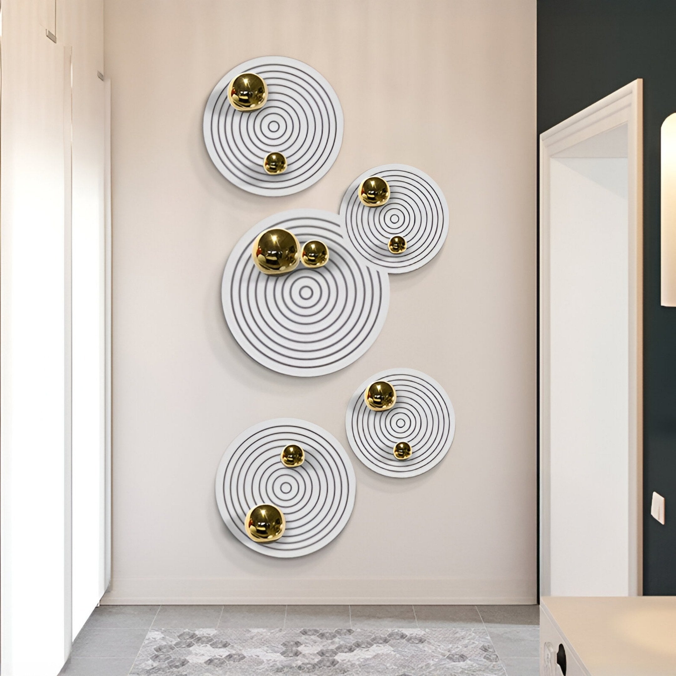 The Orbiora Gold Orb 5-Panel Concentric Sphere 3D Wall Art by Giant Sculptures features five white panels with black circles and gold accents, creating a bold modern display when arranged vertically on a light wall.