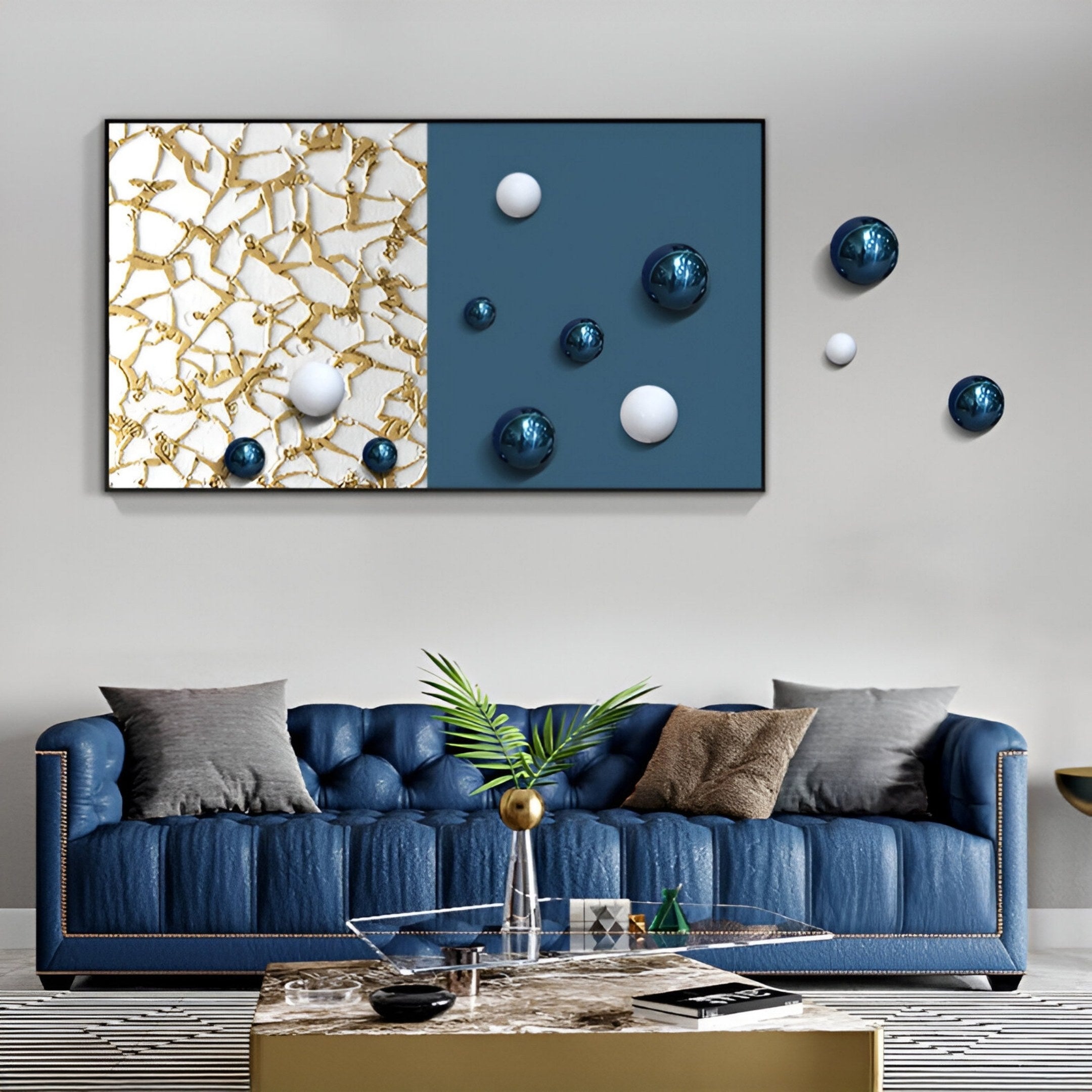 A modern living room with a blue tufted sofa, assorted pillows, a glass coffee table, and striking Spherium Blue & White Orb Dual-Tone Panel 3D Wall Art by Giant Sculptures featuring gold patterns and dynamic spheres.