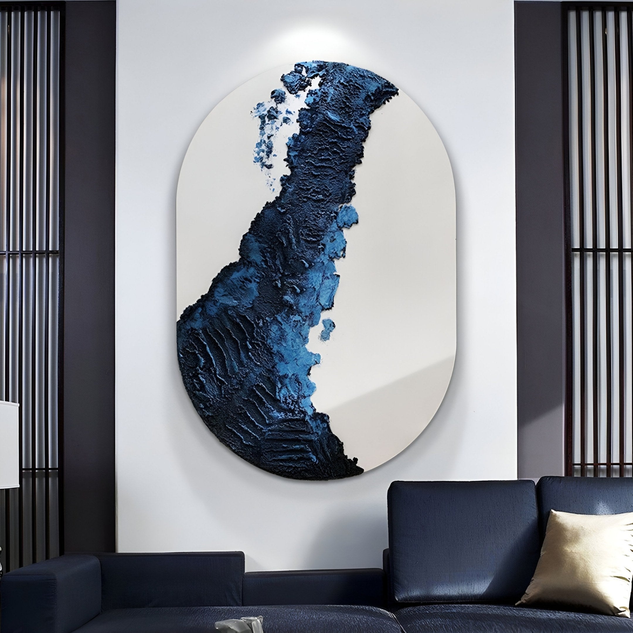 The Orrica Midnight Blue Textured Relief 3D Wall Art by Giant Sculptures, featuring dark blue and black abstract patterns, hangs above a modern navy blue sofa in a stylish living room.
