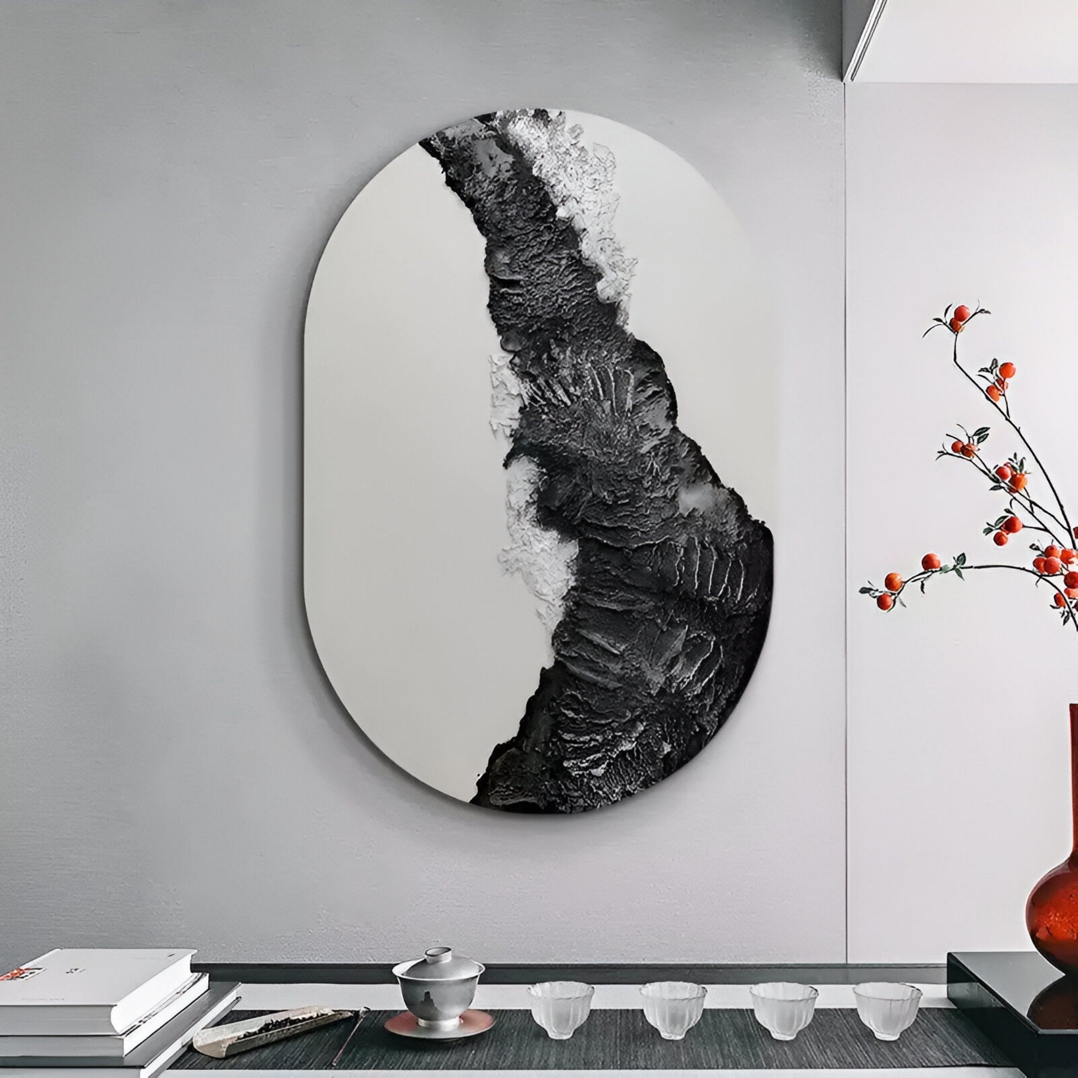 The Orrica Silver & Black Textured Relief 3D Wall Art by Giant Sculptures hangs above a minimalist tea set, while a vase with red berries accents this modern light gray room—ideal for stylish interiors.