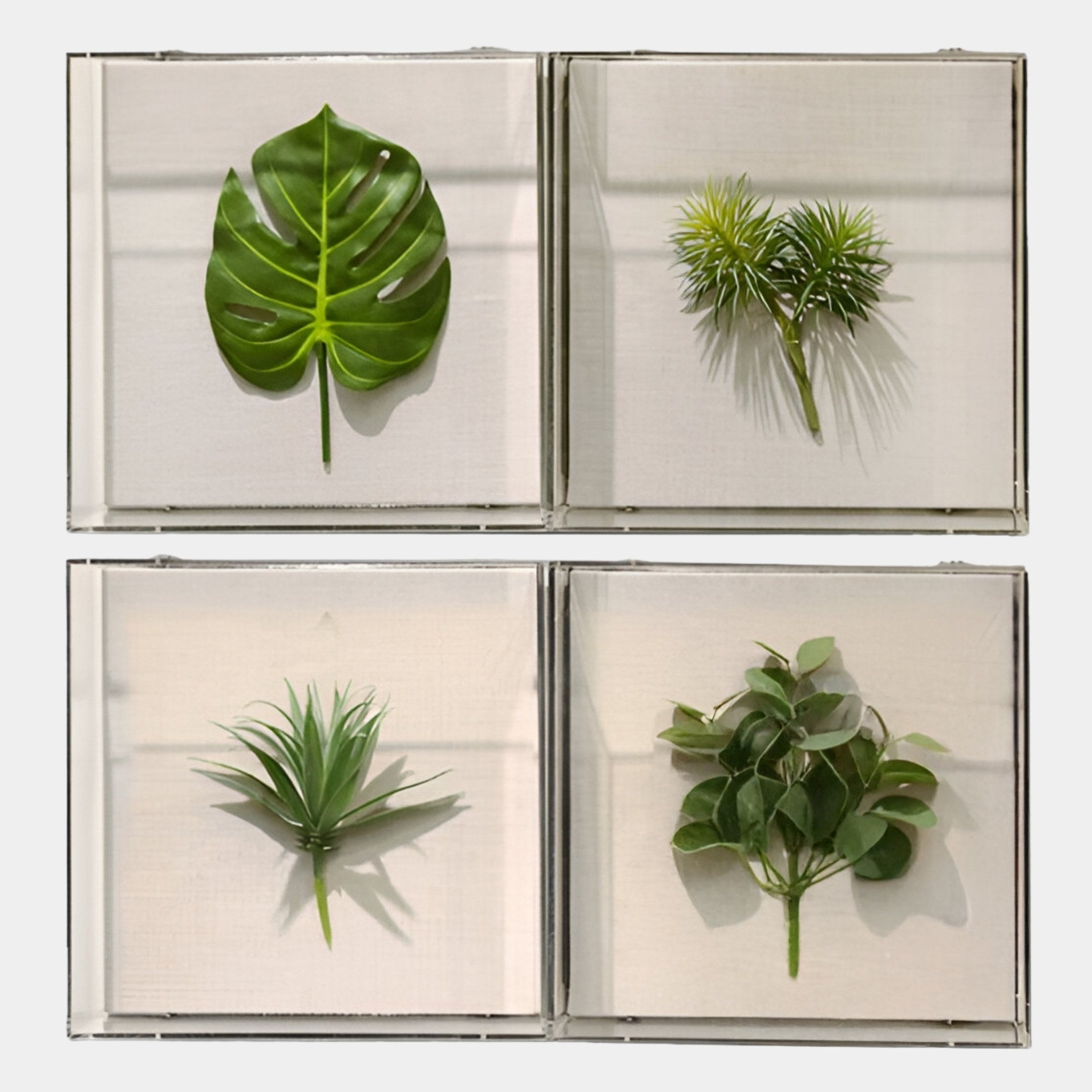 The Florvara Botanical Leaves 4-Panel Acrylic 3D Wall Art by Giant Sculptures features four square panels, each with a unique artificial leaf on a white background—ideal botanical décor for modern Nordic interiors.