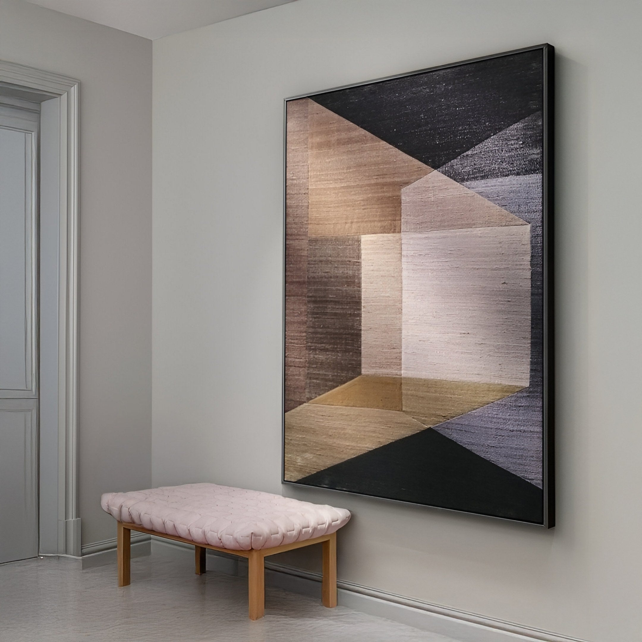 The Striatura Bronze & Charcoal Rope Abstract 3D Wall Art by Giant Sculptures hangs above a light pink tufted bench with wooden legs, adding minimalist charm to modern interiors.