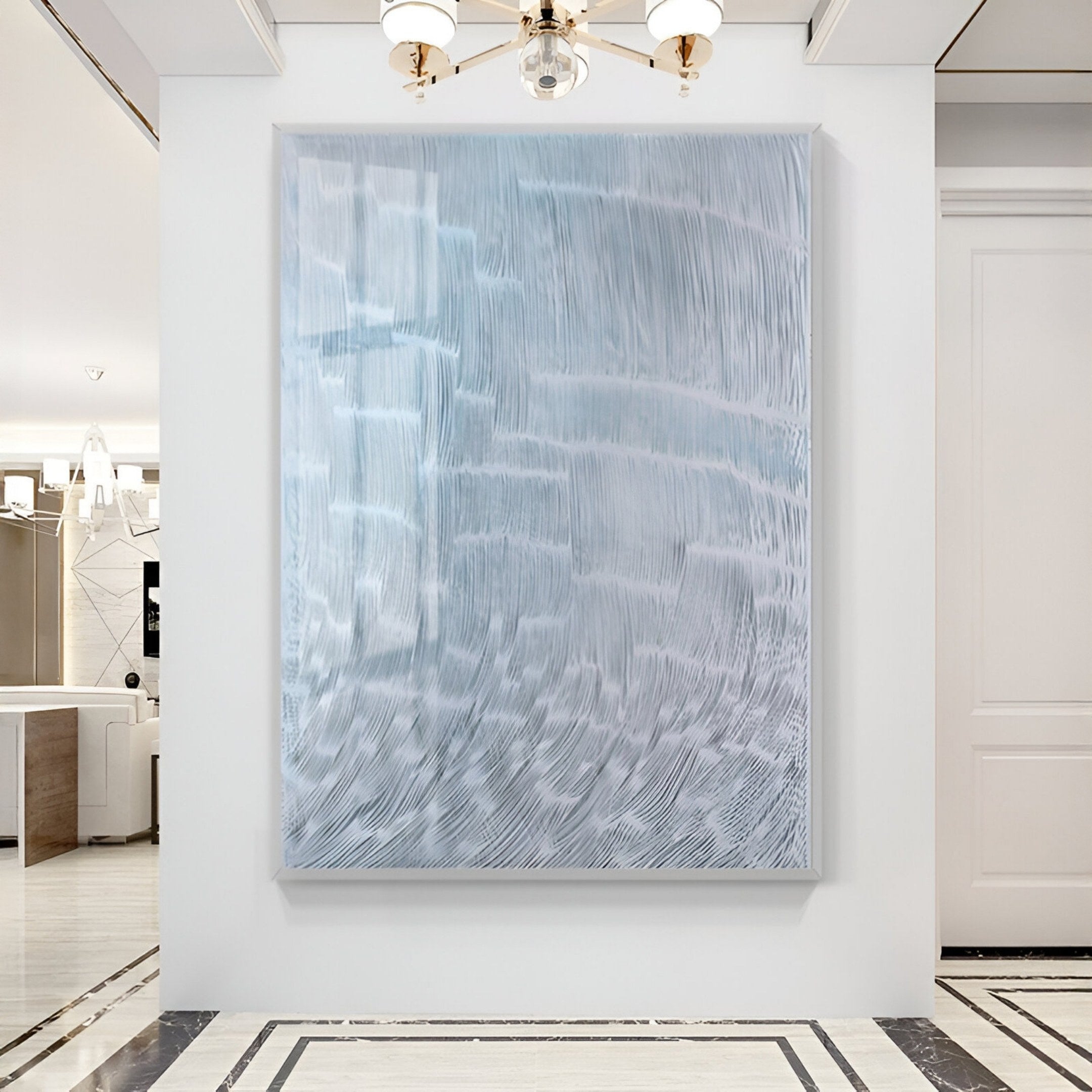 The Aqualis Frosted Ice Curve Textured Acrylic 3D Wall Art by Giant Sculptures, featuring wavy white and light blue lines, hangs on a white wall in a modern room with marble floors and minimalist decor.