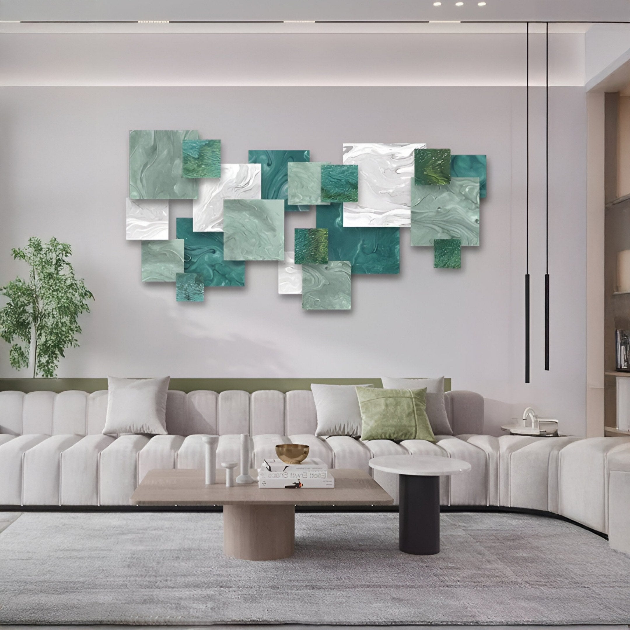 A modern living room features a large light grey sectional, round coffee table, potted plant, and the Stravane I Green & White Mosaic Oil Canvas 3D Wall Art by Giant Sculptures. Two pendant lights add the finishing touch to this contemporary space.