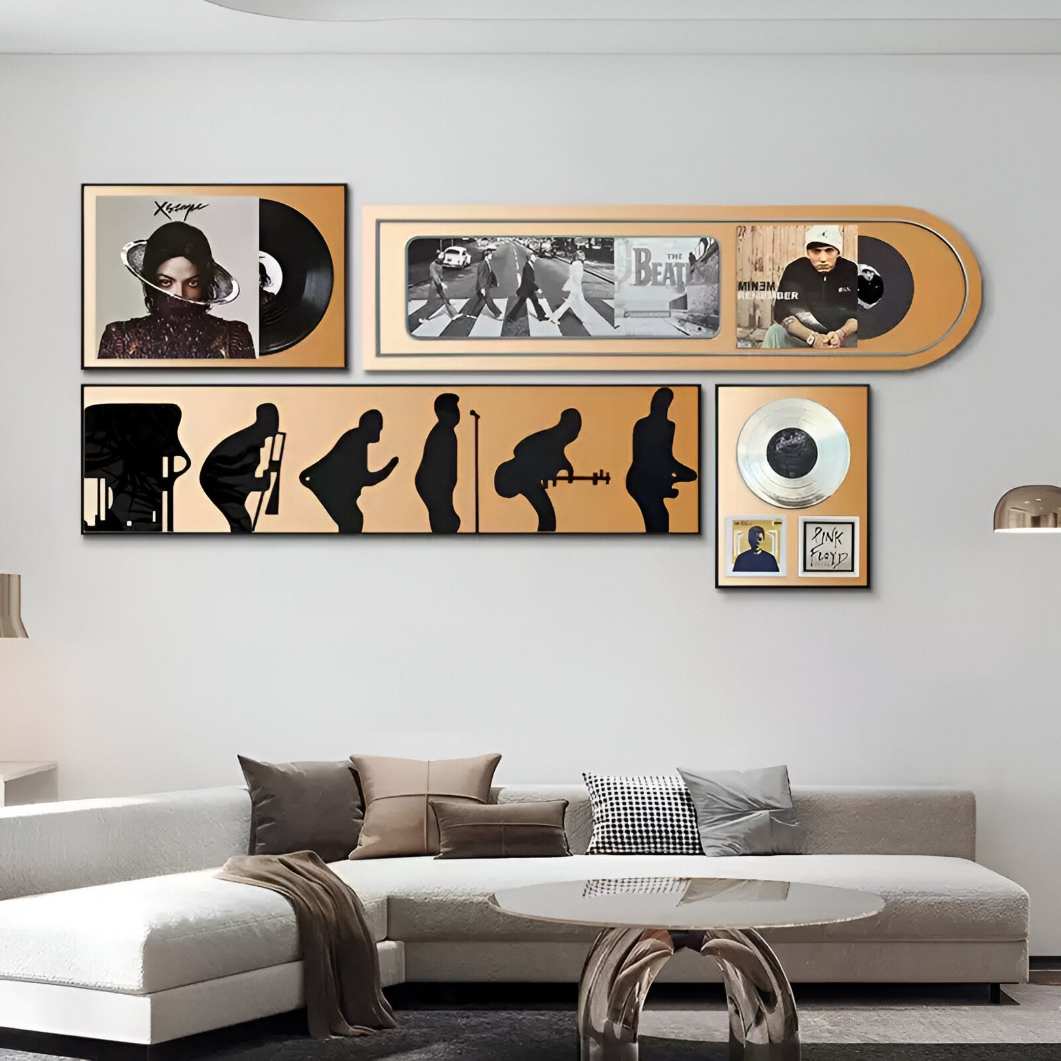 A modern living room with a white sectional sofa and pillows, featuring the Sonarta Gold Multi-Panel Record & Silhouette Wall Art by Giant Sculptures, showcasing vinyl records, album covers, musicians’ silhouettes, and decorative frames.
