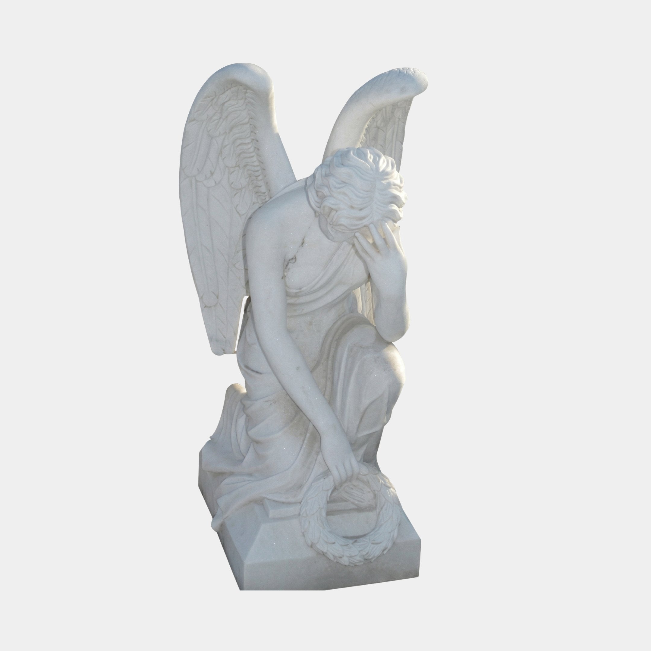 Angel With Wings Marble Outdoor Sculpture by Giant Sculptures, 120cm tall, depicting a kneeling winged female angel in a contemplative pose with one hand to her face, holding a wreath, carved in white marble on a rectangular base against a light grey background.