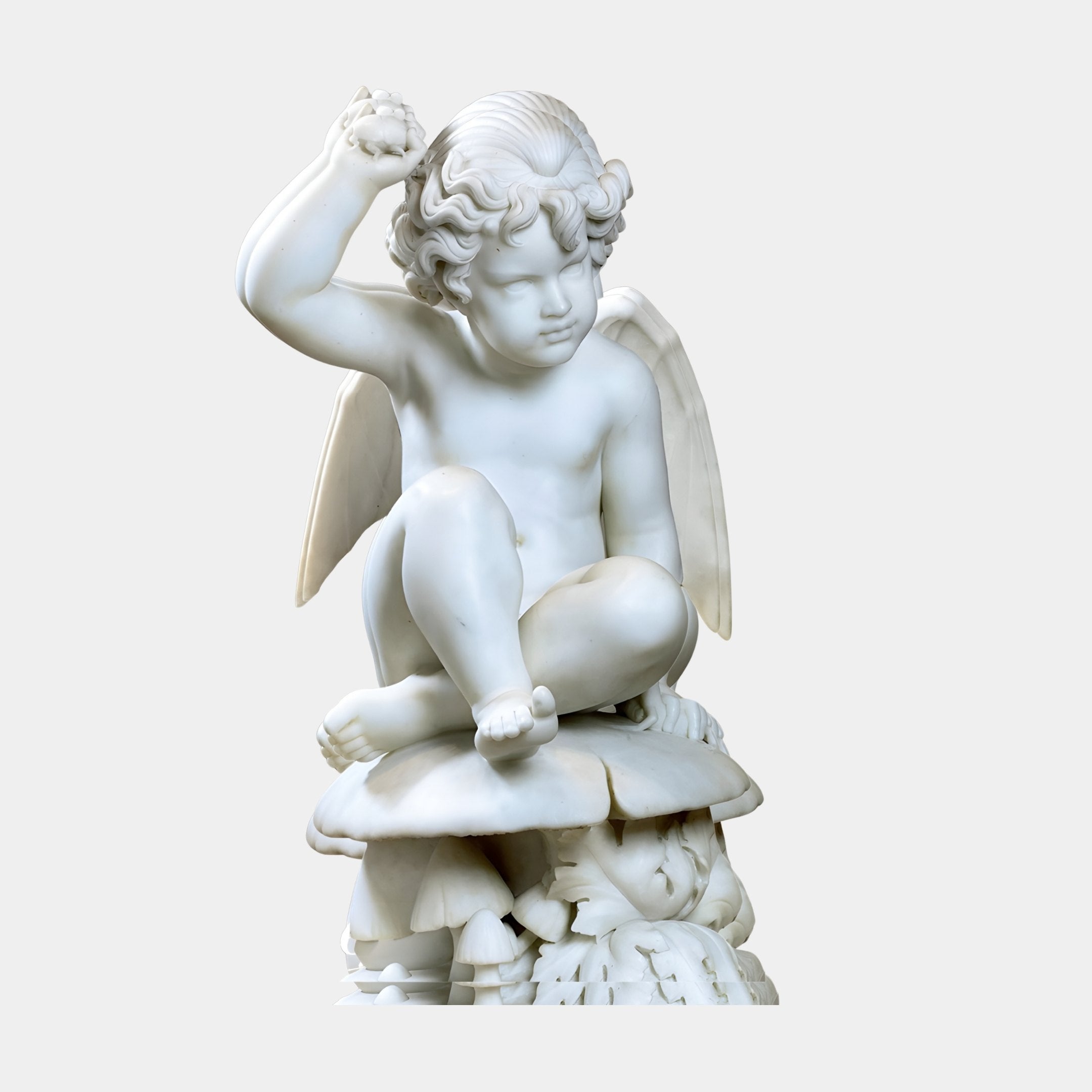 Seated Cherub Angel Marble Outdoor Sculpture by Giant Sculptures, 60cm white marble Puck figure cross-legged on mushrooms, against a plain grey background.