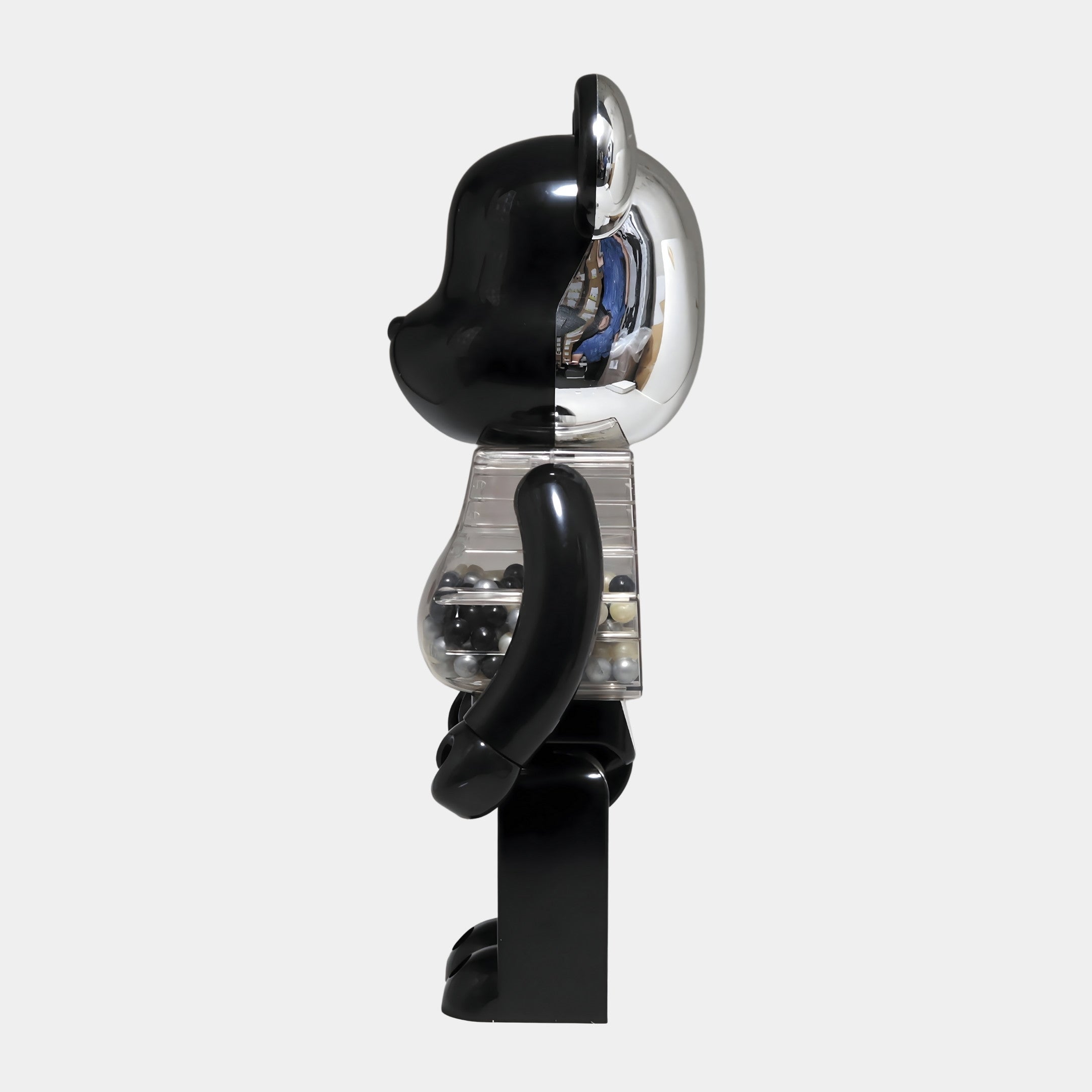 A side view of the Giant Sculptures Midnight Chrome Beads Bear Sculpture (70cm) features a black body, transparent midsection with visible spheres, and a reflective metallic head—an eye-catching accent for modern interiors.