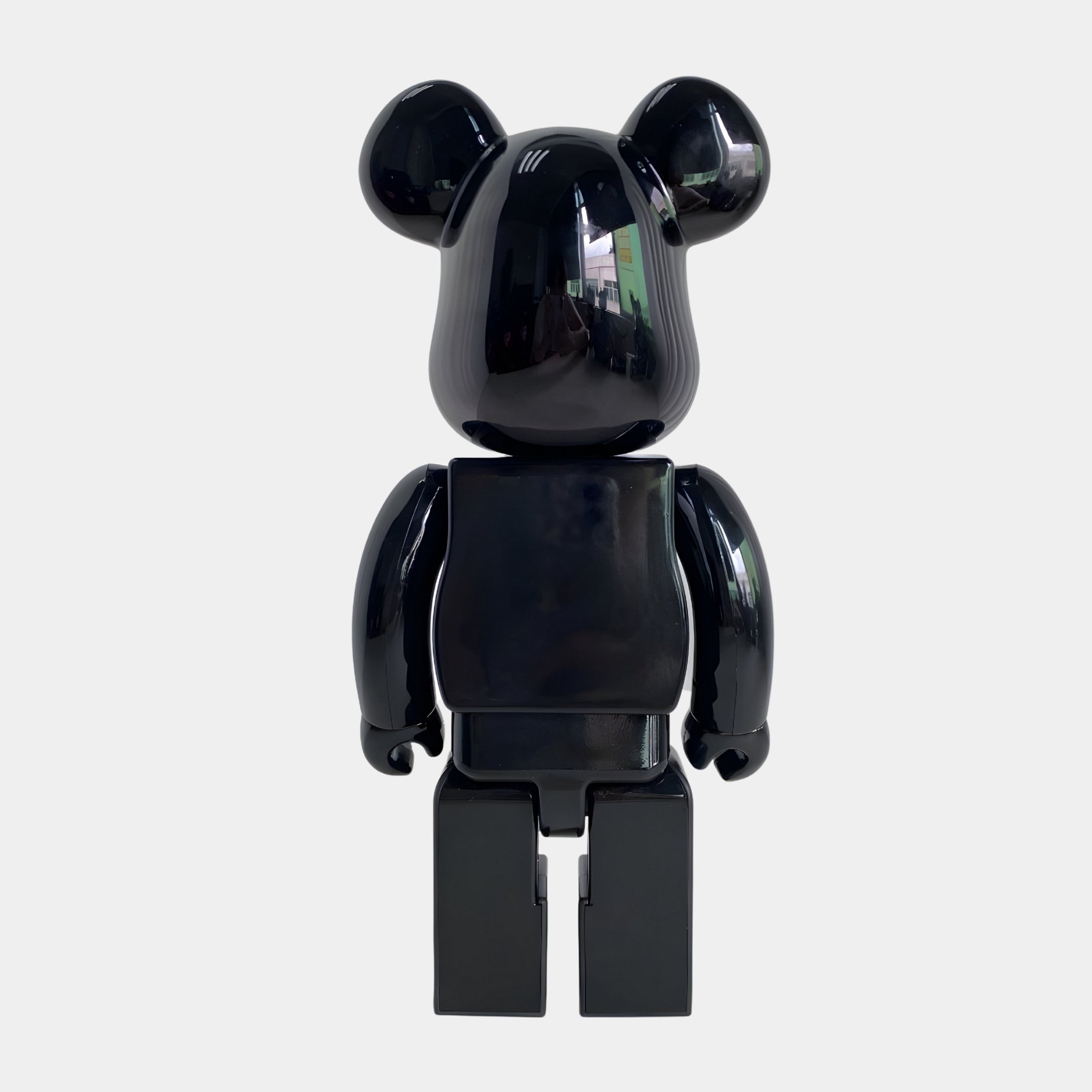 The Giant Sculptures Midnight Crest Bear Sculpture - 70cm is a glossy black bear-shaped figure with rounded ears, a blocky body, and articulated limbs in piano-gloss resin, shown upright against a plain white background.