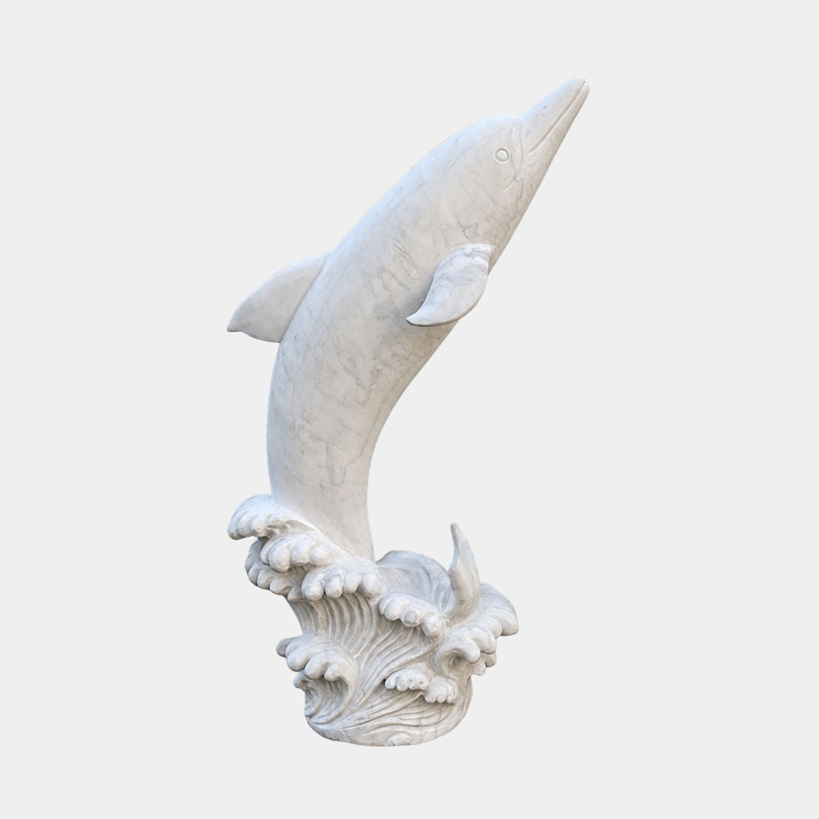 White marble dolphin leaping from a carved wave, flukes dropping in beneath