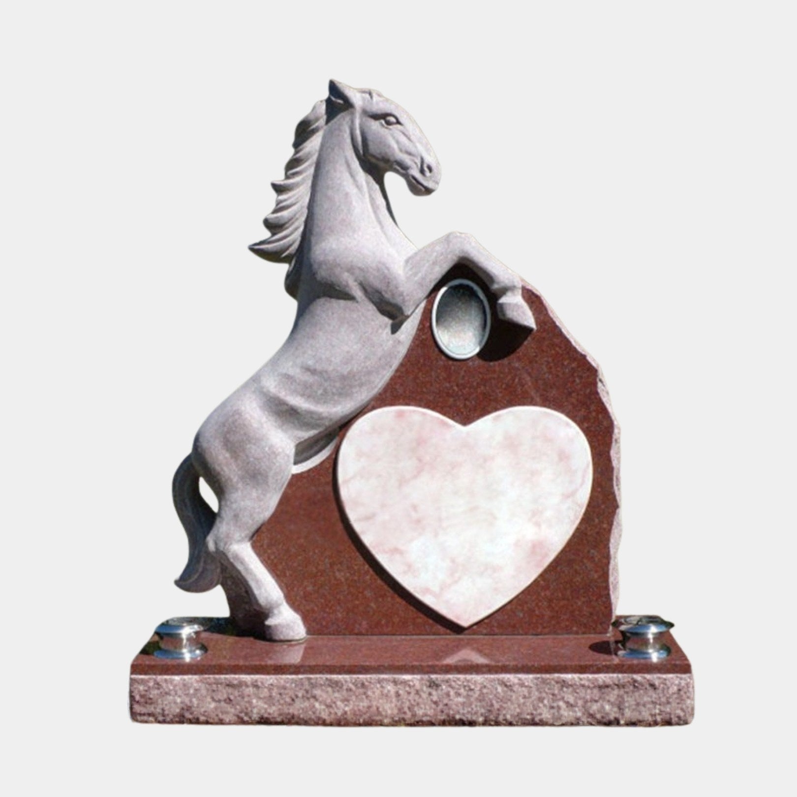 Grey granite rearing horse beside a red granite memorial tablet