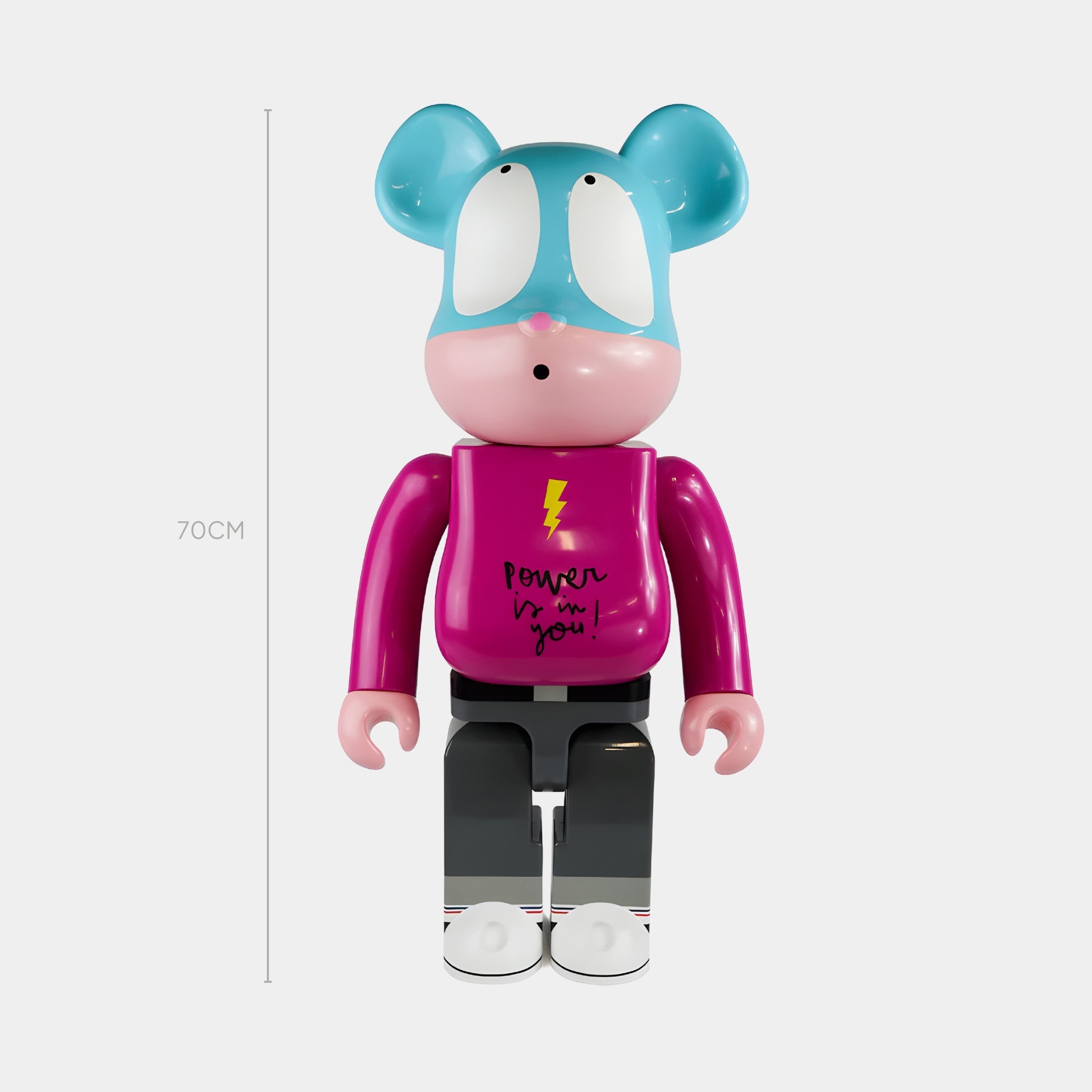 The Power Surge Pop Bear Sculpture - 70cm by Giant Sculptures features a blue bear head, wide eyes, and a magenta Power is in you! shirt—crafted in glossy resin, its a vibrant piece ideal for contemporary spaces.