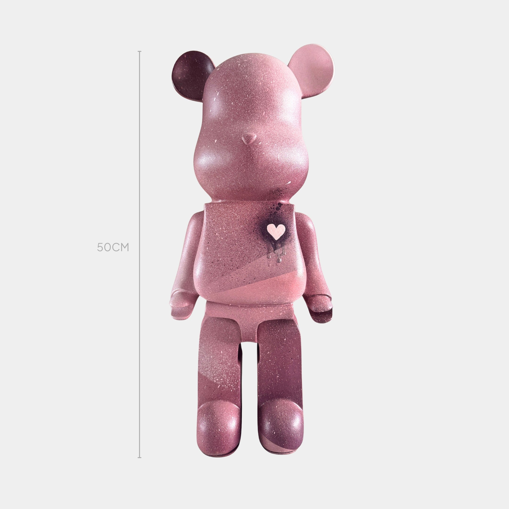 The Giant Sculptures Pinque Bear Sculpture - 50cm is a limited edition figurine featuring a pink gradient and a white heart on its chest, sitting upright against a plain white background—a charming contemporary art piece.