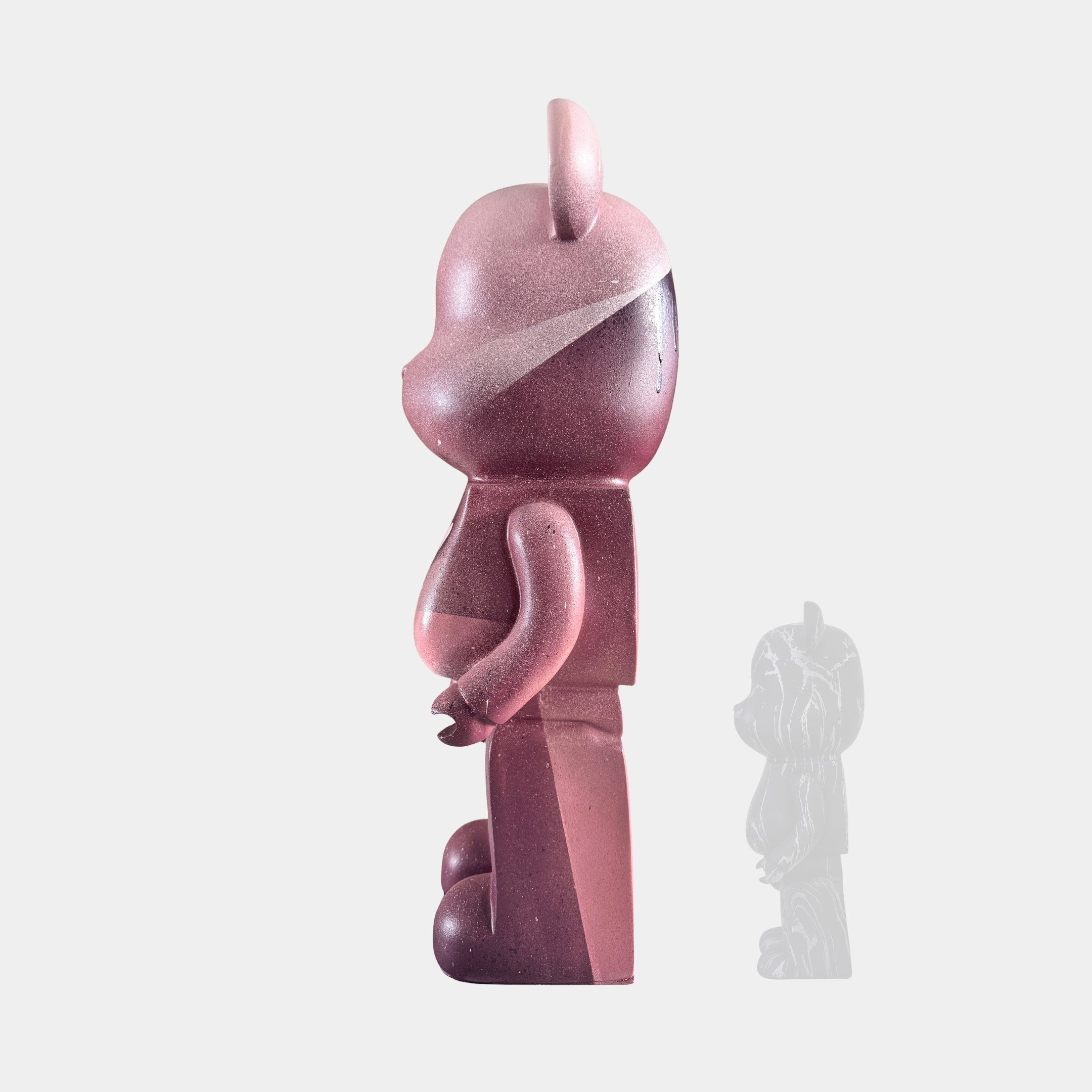 The Pinque Bear Sculpture - 50cm by Giant Sculptures features a pink bear in profile facing left, with a faded duplicate behind it on a white background—a bold, contemporary art piece.