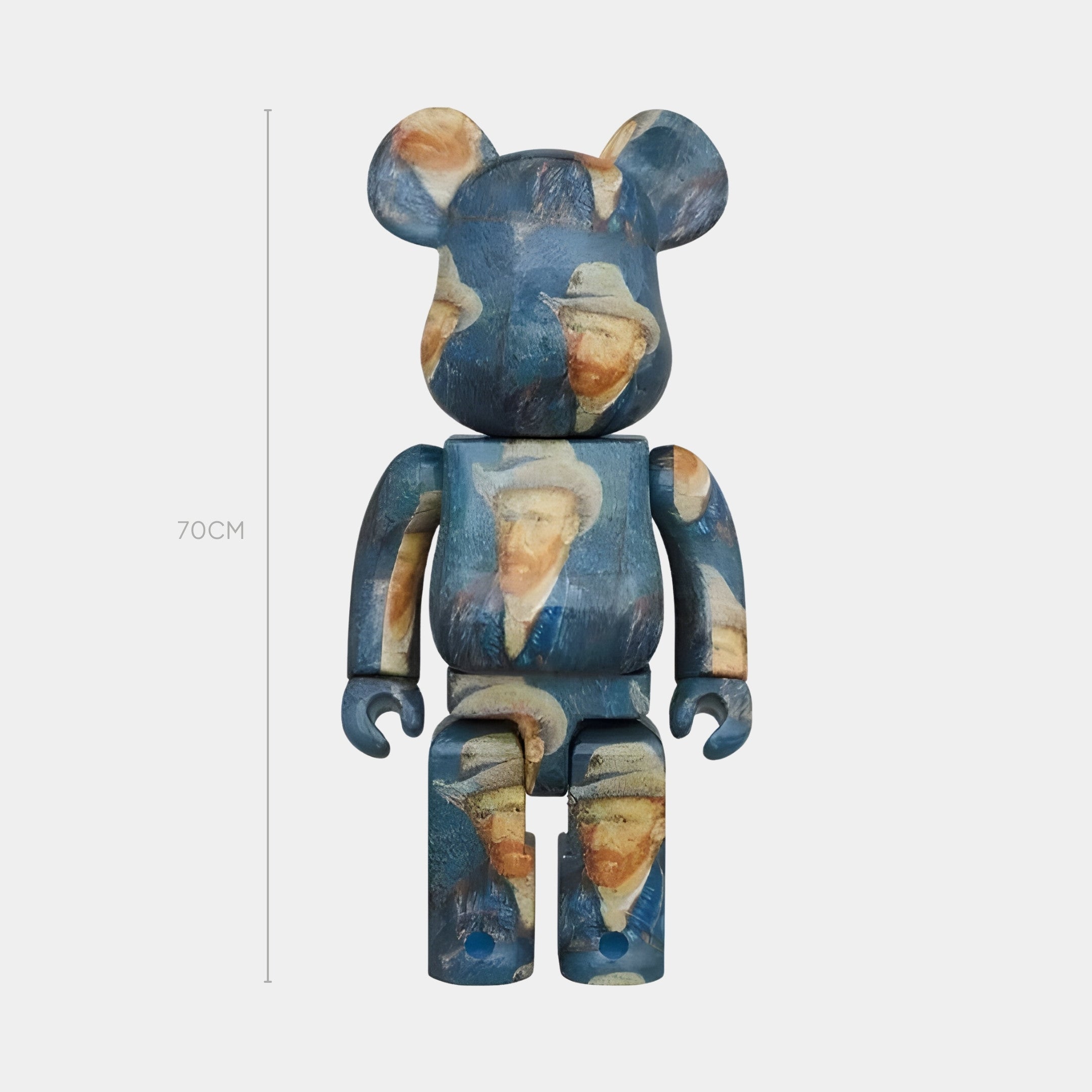 The Portrait Bleu Art Bear Sculpture by Giant Sculptures is a 70cm tall contemporary blue resin bear, decorated with images of a hat-wearing man inspired by van Goghs self-portraits, set against a plain light background.