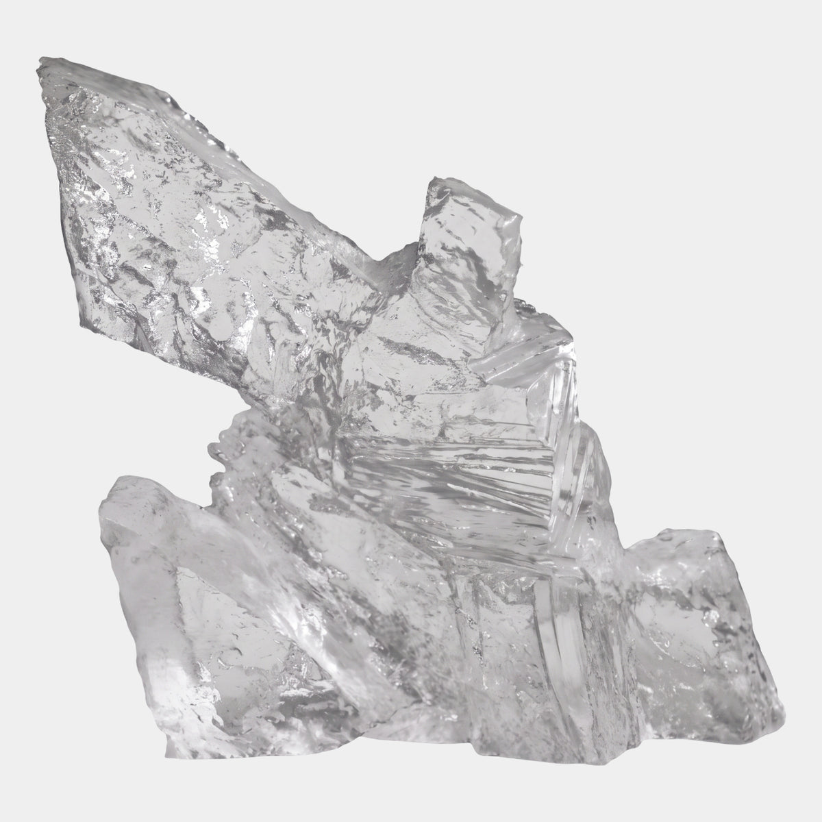 Clear Reclining Torso Cast Resin Sculpture - 28cm, an abstract clear resin form with jagged, faceted planes, shown against a plain light grey background.