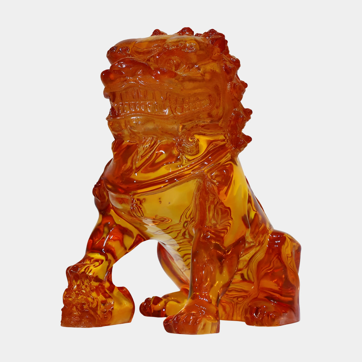 Amber Guardian Lion with Ball on the Left cast resin sculpture, 38cm, seated with paw on a carved ball, glossy amber-orange tones, on a plain white background.