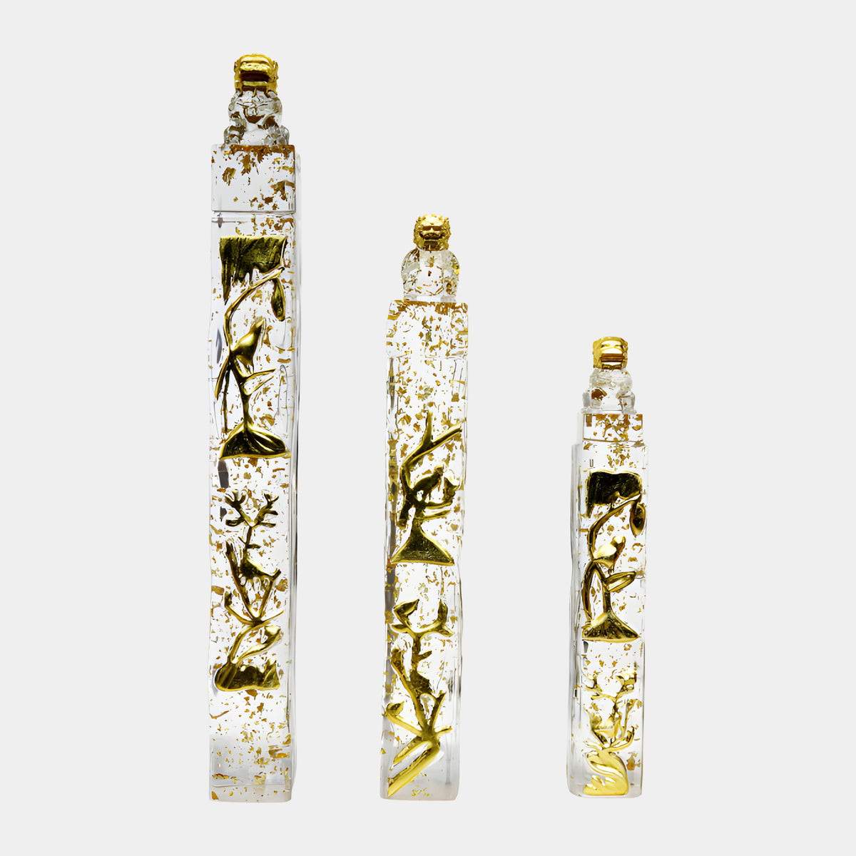 Three clear resin columns with gold flecks and gilded bird-and-branch relief, each topped by a guardian lion finial, shown in heights 112/135/168cm on a plain white background.