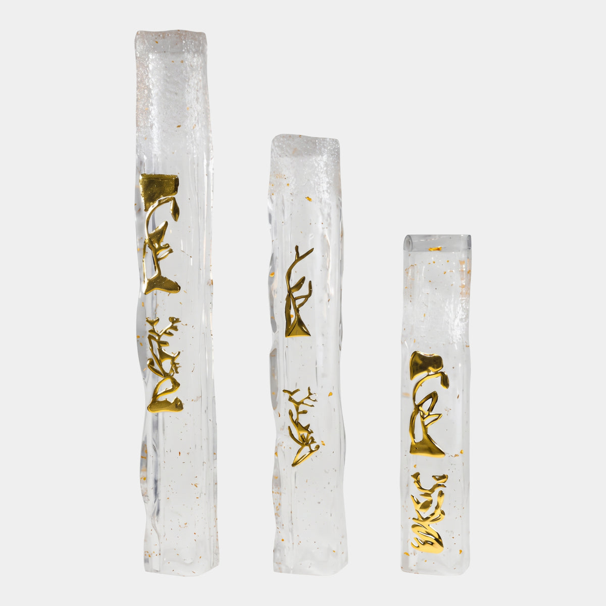 Gold Bird Relief Frosted Crown Resin Column by Giant Sculptures, three heights with gold-toned bird-and-branch reliefs on clear, gold-flecked columns with frosted crowns, set against a plain white background.