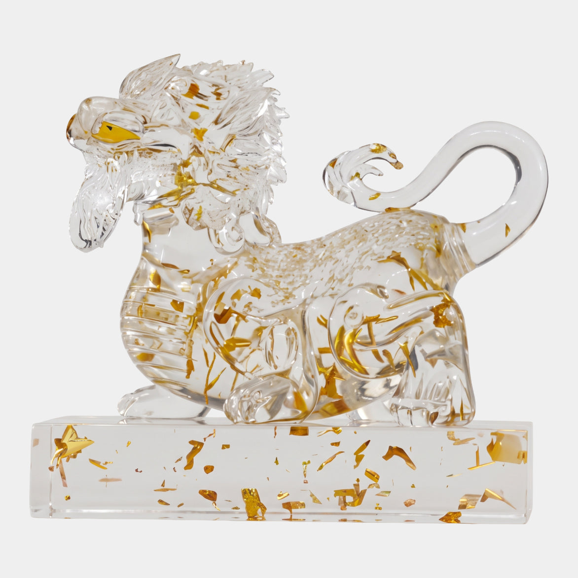 Clear Gold-Leaf Maned Beast on a Base - 20cm, a crouched lion-like resin sculpture with gold-leaf flecks and gold eyes, tail curled over its back, on a clear rectangular base against a white background.