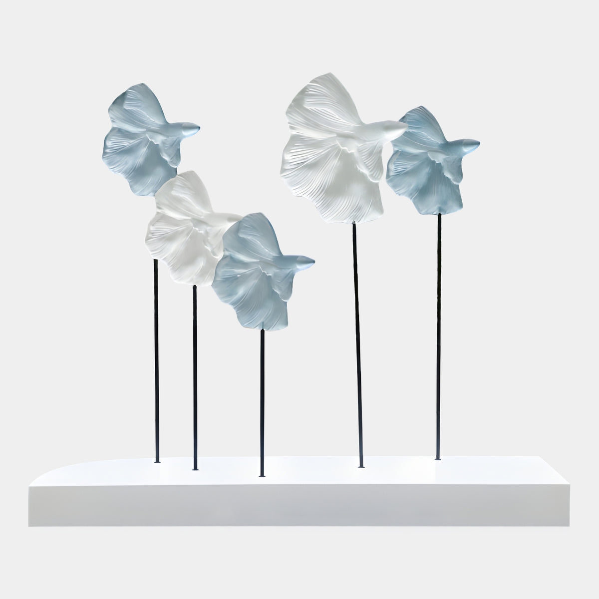Blue Five-Fish Group on Marble - 200cm by Giant Sculptures, five fin-ridged fish in blue and white atop slender black rods on a white marble base, plain light background.