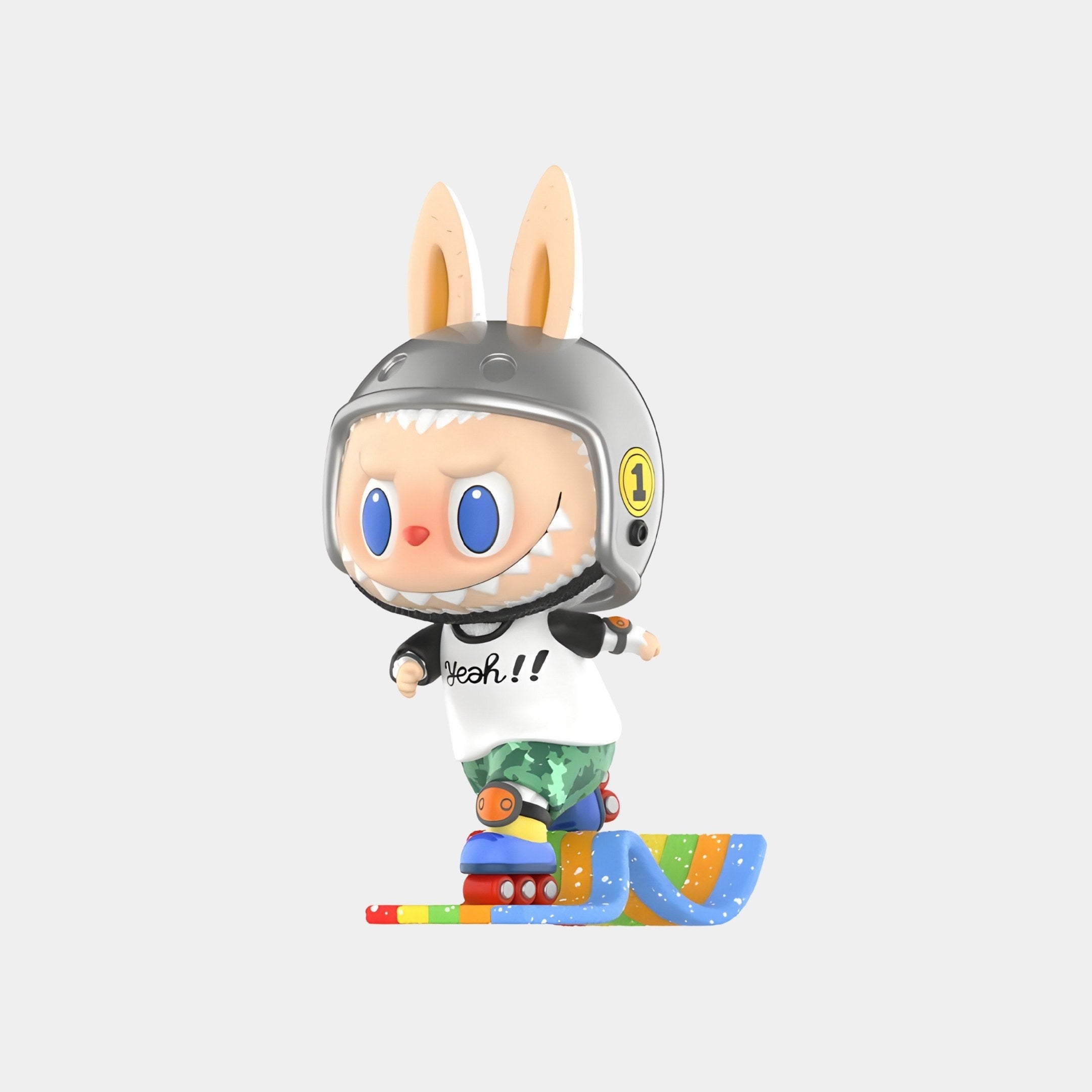 The Giant Sculptures Rainbow Candy Labubu Figure (7-10cm) features bunny ears, a gray helmet, blue eyes, and a white "Yeah!!" shirt, standing on colorful skates atop a wavy ramp—an art collectible set against a plain background.